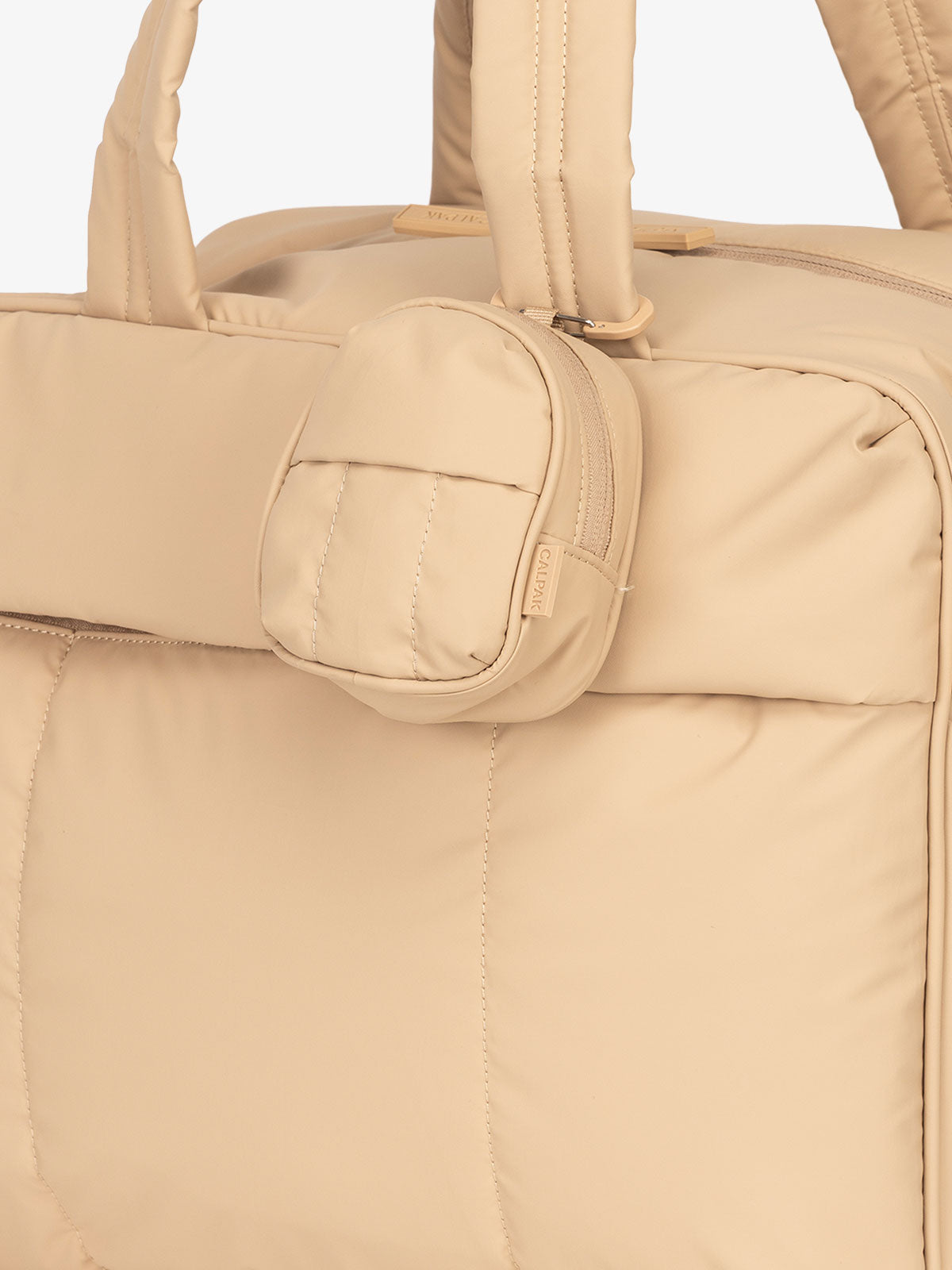 CALPAK Luka mini backpack keychain attached to duffel with carabiner clip in brown; AMB2201-LATTE