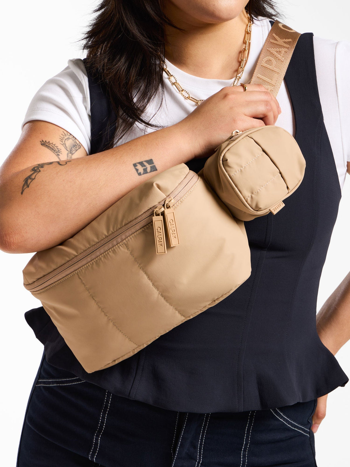Model wearing CALPAK Luka Key Pouch attached to Luka Belt Bag in latte; AMB2201-LATTE