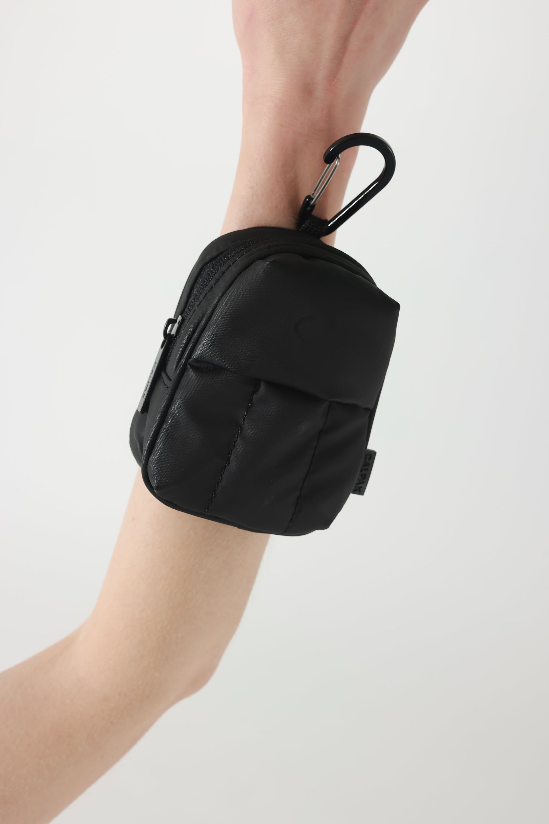 CALPAK Luka backpack key chain with back versatile elastic wrist strap and carabiner clip in matte black; AMB2201-MATTE-BLACK