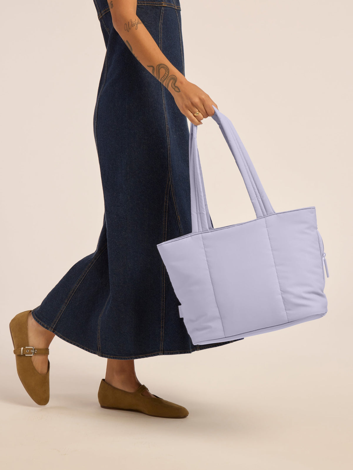 Model holding the CALPAK Luka Mini Tote in purple lavender in Orchid; ALM2401-ORCHID