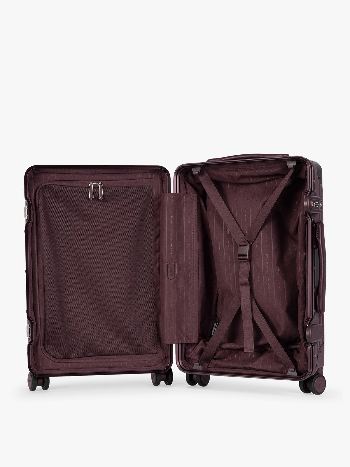 Opened CALPAK Vault deep red Dark Cherry hard-shell spinner Carry On Luggage with a telescoping handle extended, featuring a deep red leatherette side handle and trim, set against a plain light gray background; LVT1020-DARK-CHERRY