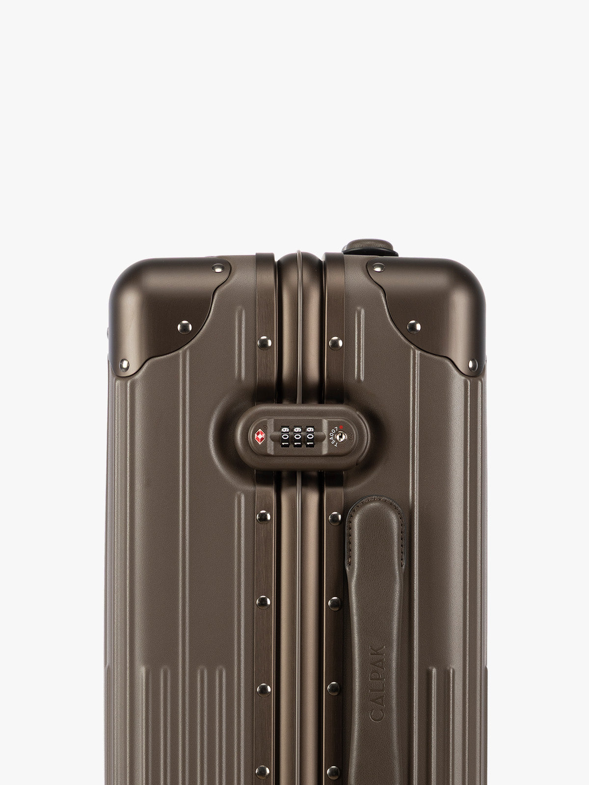 Close up of the TSA-approved lock of CALPAK Vault brown Mushroom hard-shell spinner Carry On Luggage with a telescoping handle extended, featuring a black leatherette side handle and trim, set against a plain light gray background; LVT1020-MUSHROOM