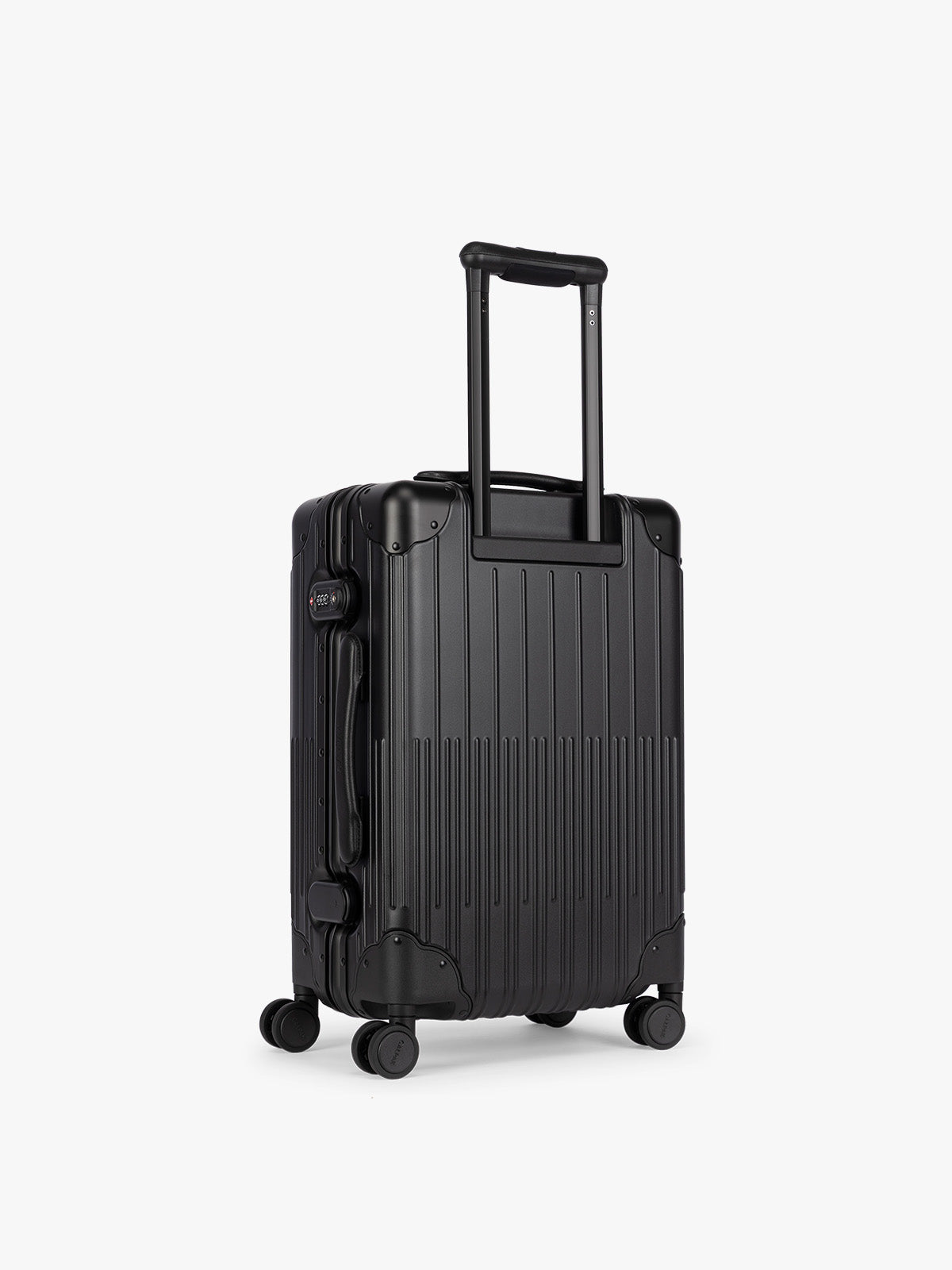 Backside of CALPAK Vault black Onyx hard-shell spinner Carry On Luggage with a telescoping handle extended, featuring a Black leatherette side handle and trim, set against a plain light gray background; LVT1020-ONYX