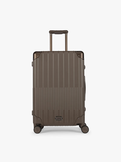 CALPAK Vault luggage brown Mushroom hard-shell spinner suitcase with a ribbed vertical design, shown from the front against a clean white background; LVT1024-MUSHROOM