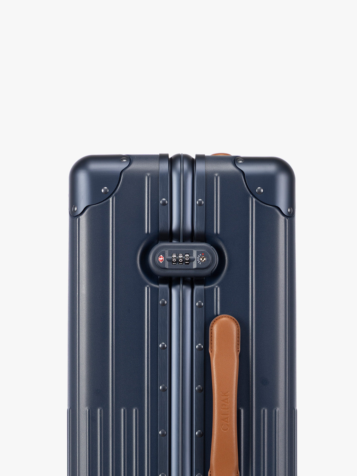 Closeup of TSA-approved lock of CALPAK Vault Luggage blue Navy hard-shell spinner suitcase with a ribbed vertical design, shown from the front against a clean white background; LVT1024-NAVY