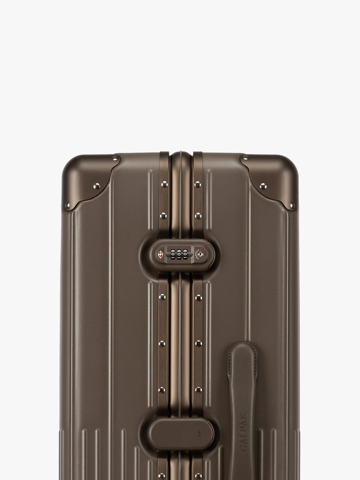 Closeup of TSA-approved lock of CALPAK Large Vault Luggage in brown Mushroom with hard-shell spinner suitcase with a ribbed vertical design, shown from the front on a light gray background; LVT1028-MUSHROOM
