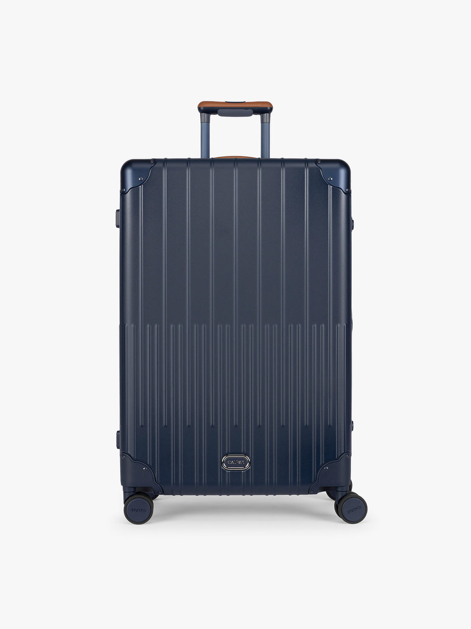 CALPAK Large Vault Luggage in blue Navy with hard-shell spinner suitcase with a ribbed vertical design, shown from the front on a light gray background; LVT1028-NAVY