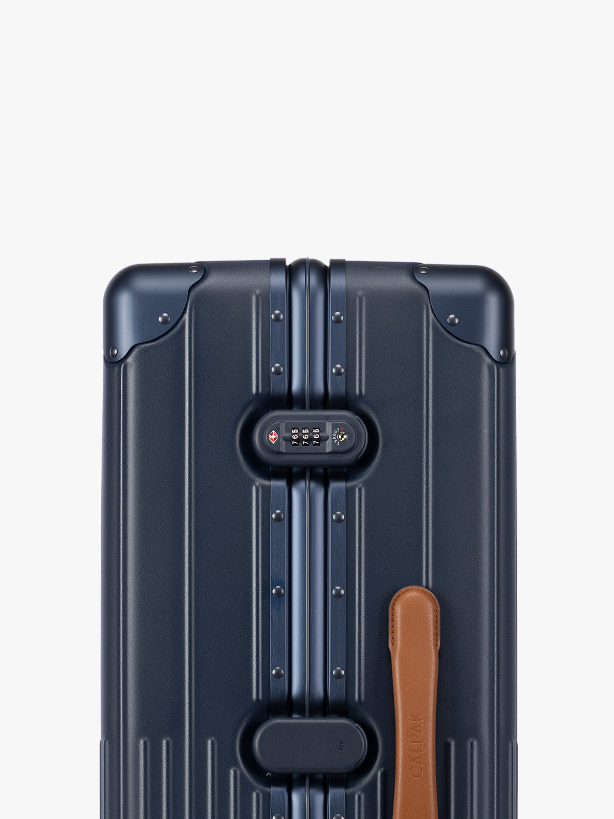 Closeup of TSA-approved lock of CALPAK Large Vault Luggage in blue Navy with hard-shell spinner suitcase with a ribbed vertical design, shown from the front on a light gray background; LVT1028-NAVY