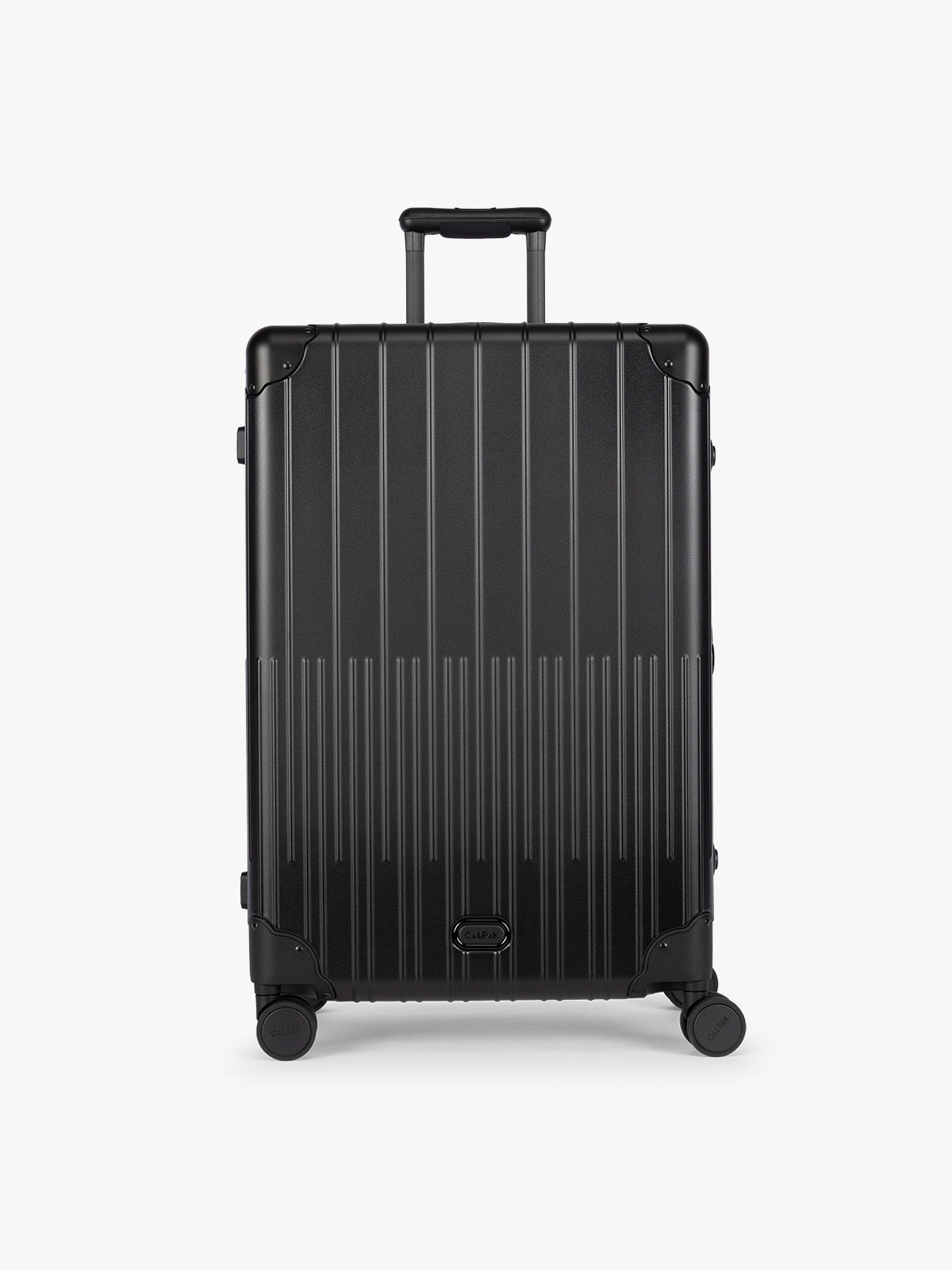 CALPAK Large Vault Luggage in black Onyx with hard-shell spinner suitcase with a ribbed vertical design, shown from the front on a light gray background; LVT1028-ONYX