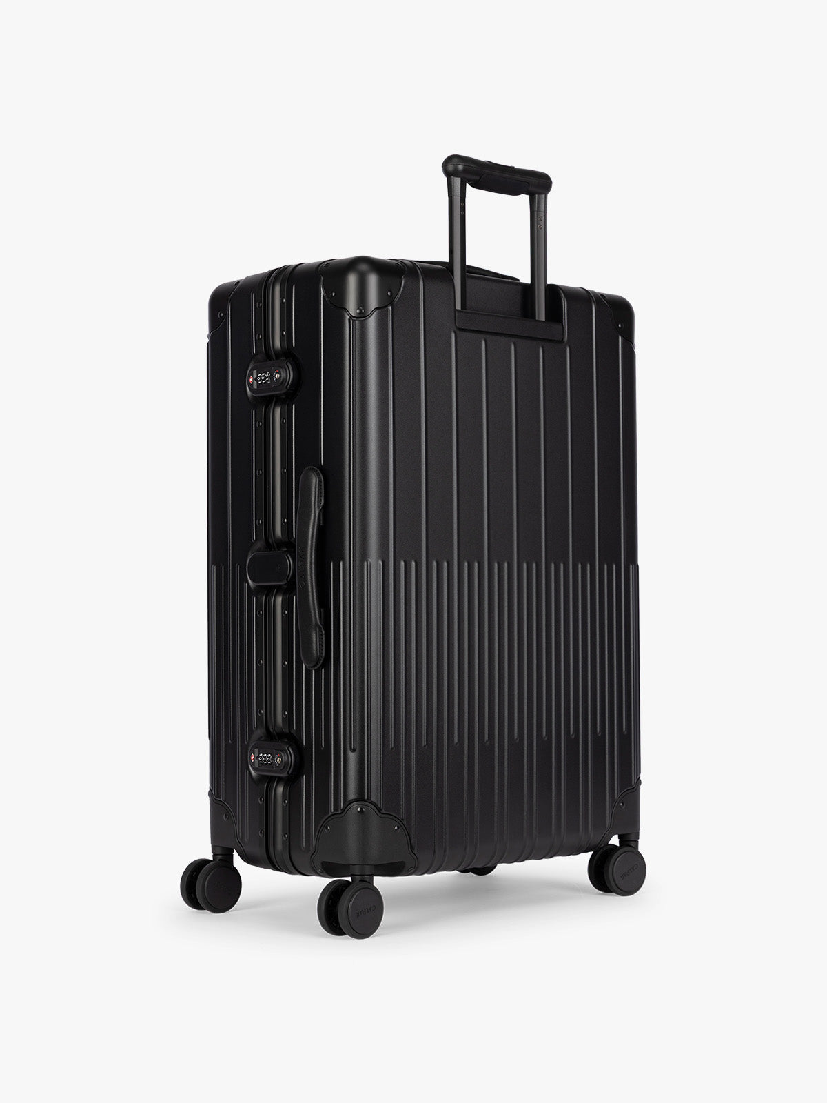 Backside of CALPAK Large Vault Luggage in black Onyx with hard-shell spinner suitcase with a ribbed vertical design, shown from the front on a light gray background; LVT1028-ONYX