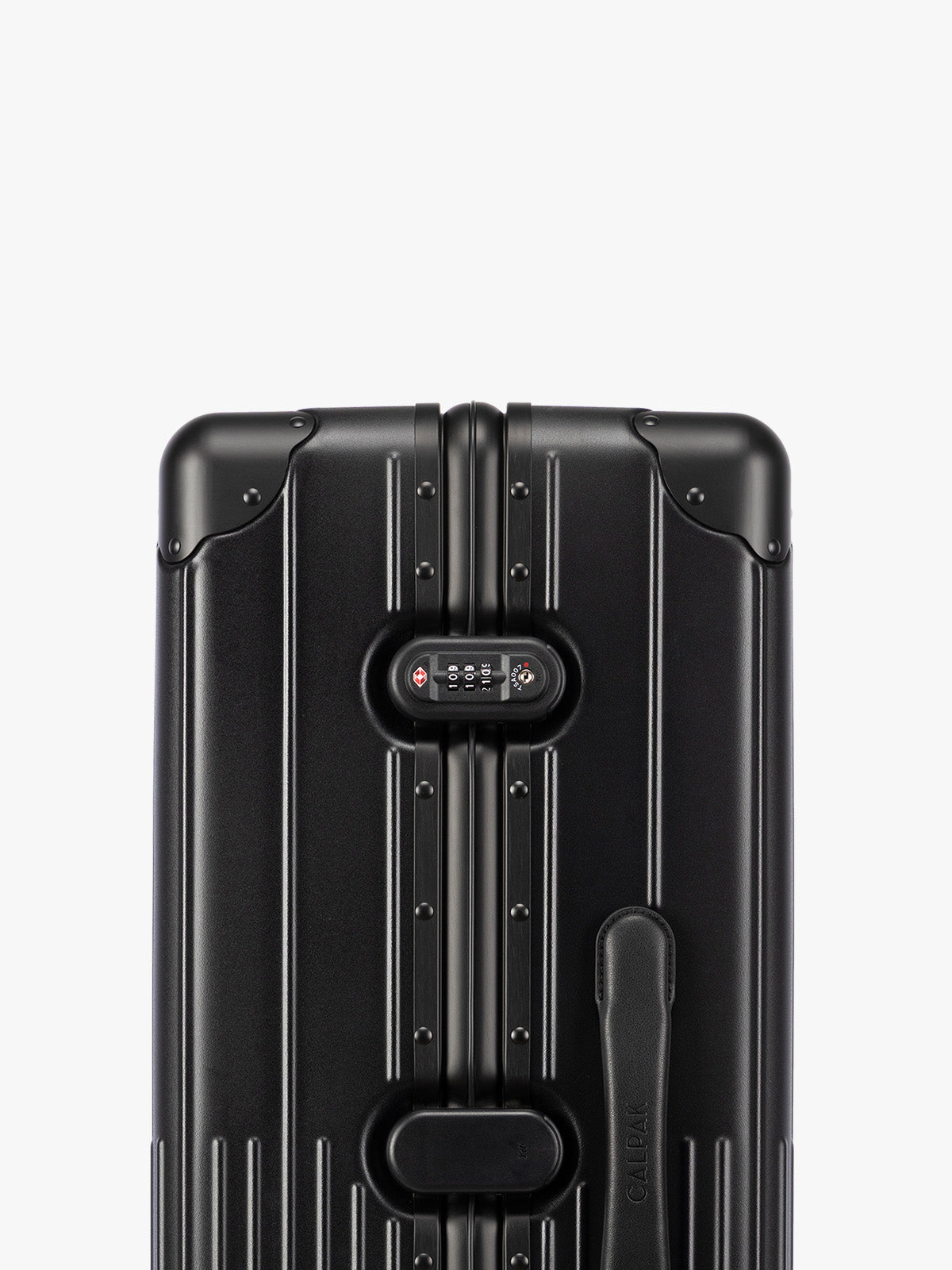 Closeup of TSA-approved lock of CALPAK Large Vault Luggage in black Onyx with hard-shell spinner suitcase with a ribbed vertical design, shown from the front on a light gray background; LVT1028-ONYX