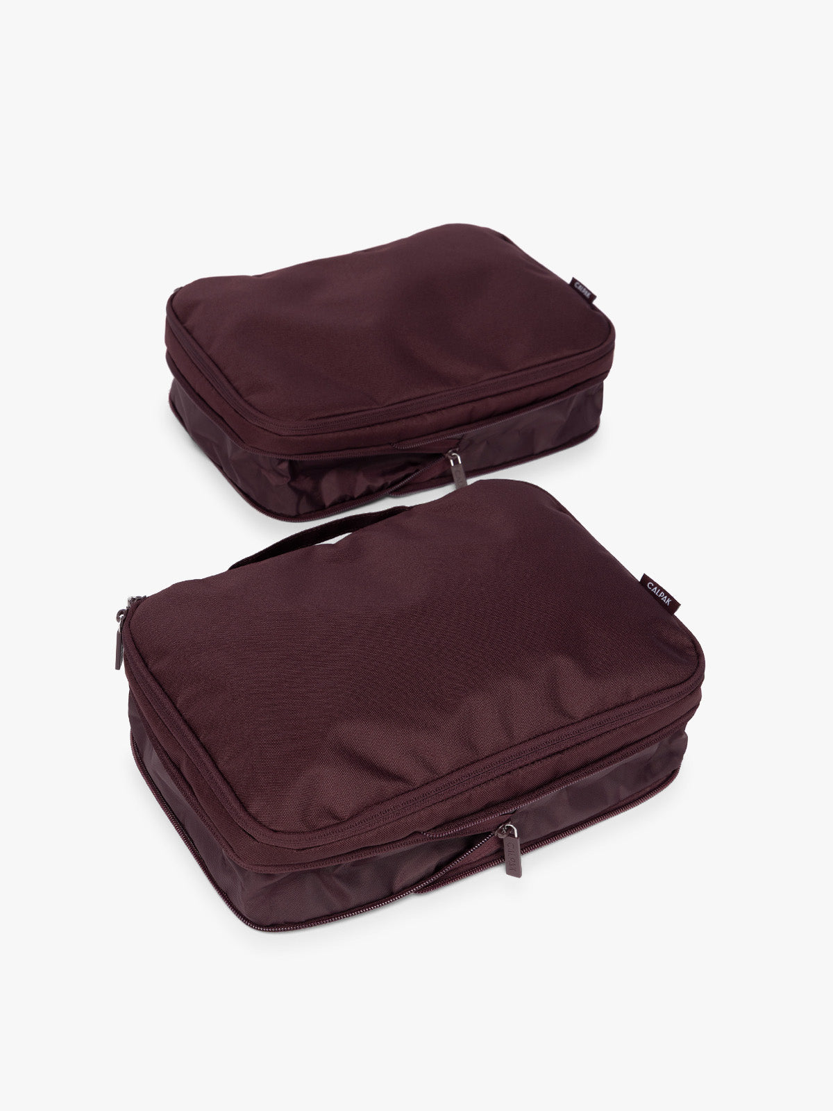 Two burgundy Dark Cherry CALPAK Medium Compression Packing Cubes with zippers shown on a clean white background shown uncompressed; PCC2201-DARK-CHERRY