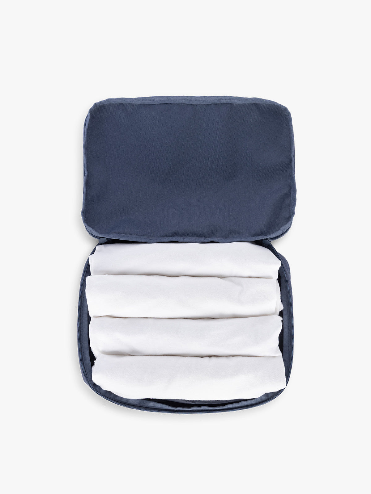 Towels rolled up in CALPAK Medium Compression Packing Cubes (Set of 2) in dark blue Indigo; PCC2201-INDIGO