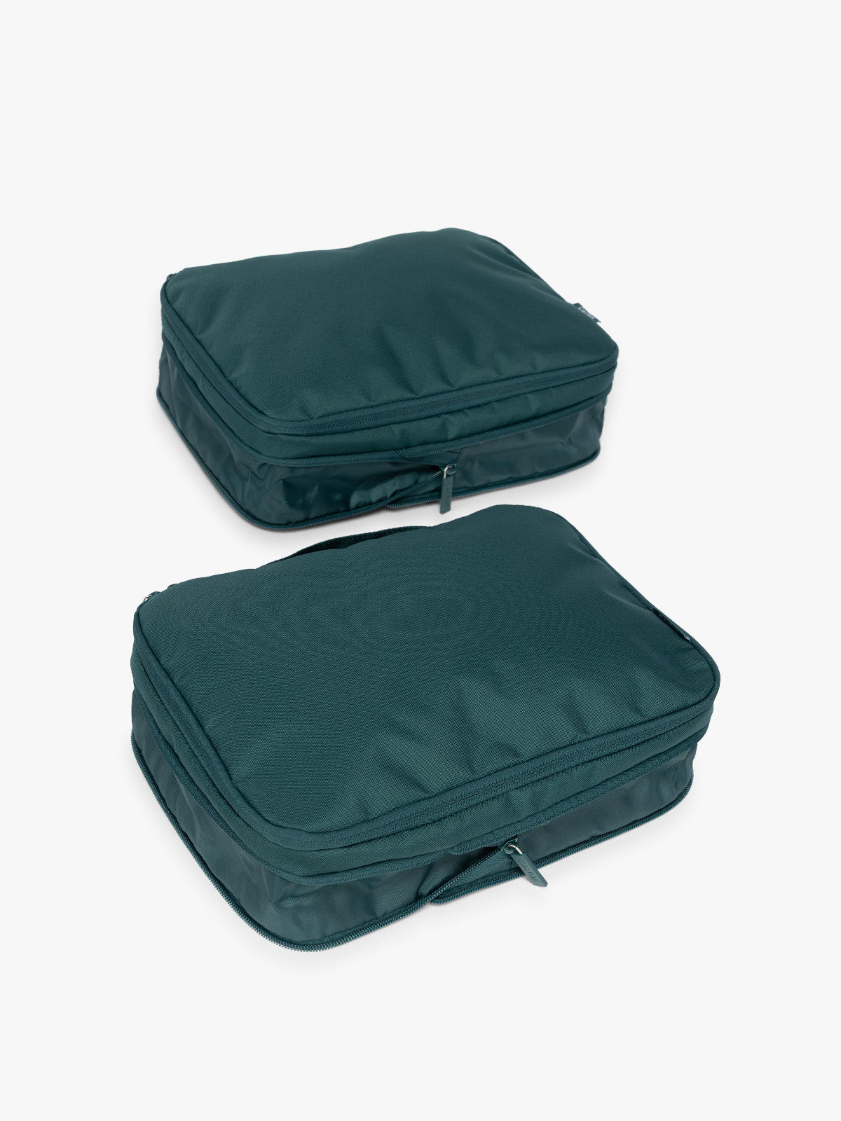 Two dark green teal Kale CALPAK Medium Compression Packing Cubes with zippers shown on a clean white background in an uncompressed view; PCC2201-KALE