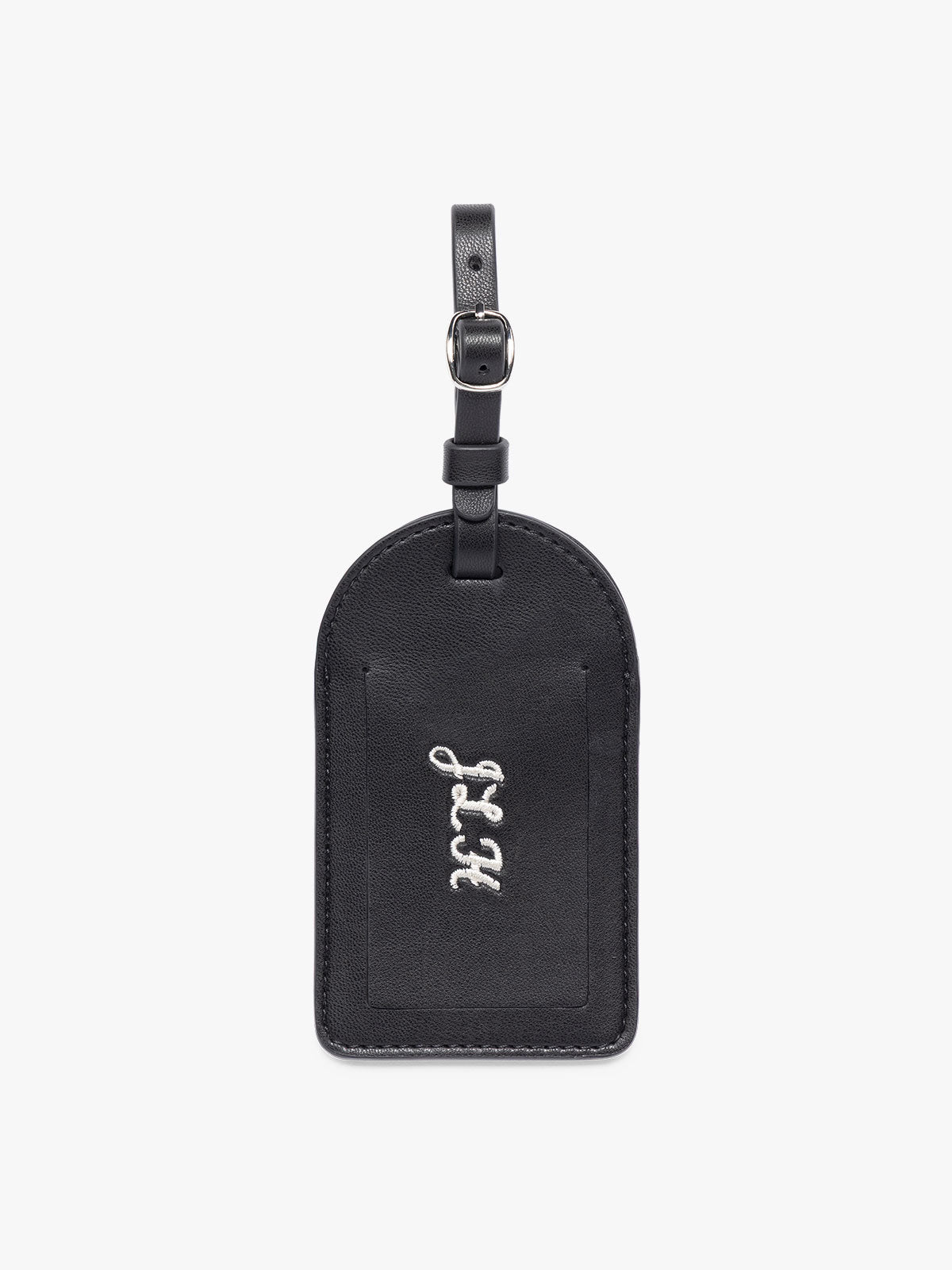 A black CALPAK Luggage Tag with a matching strap and silver-tone metal buckle, featuring embroidered intials "JLH", shown on a clean white background; PWTS2601-BLACK