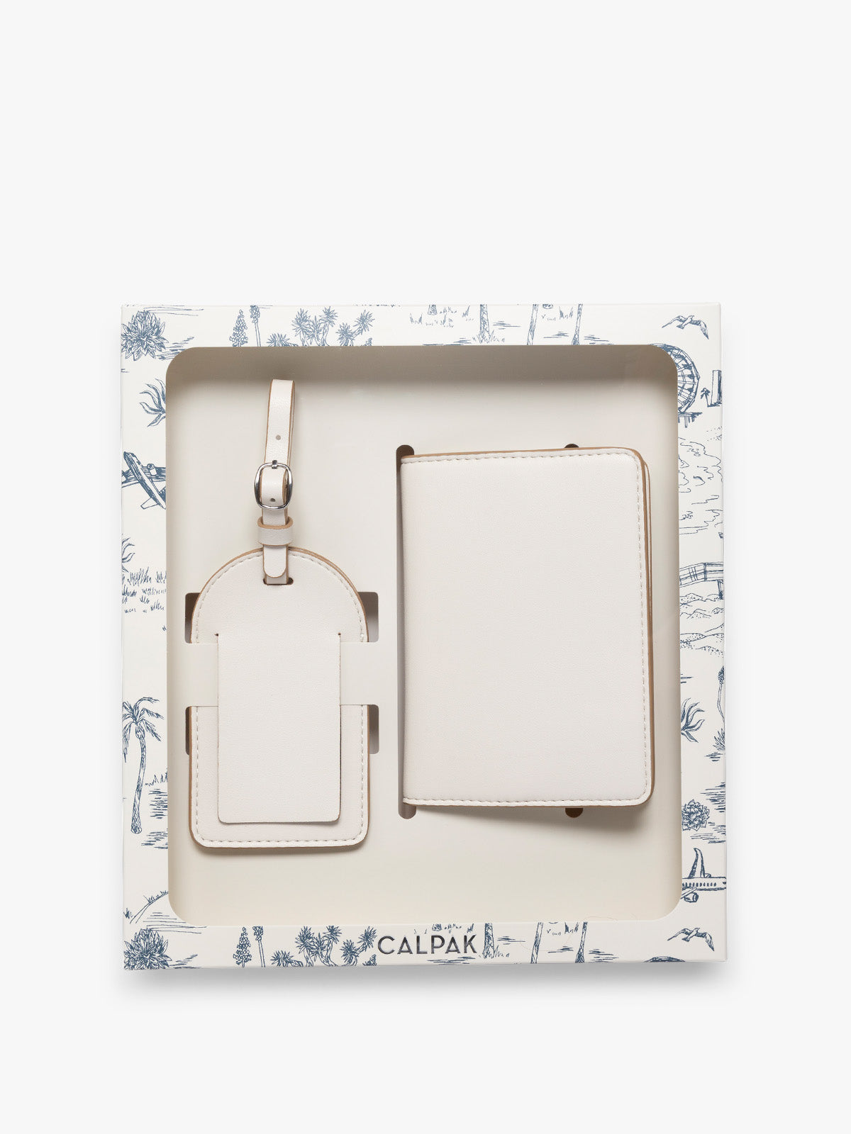 A two-piece CALPAK Luggage Tag and Passport Holder Set in a cream color, presented inside a blue decorated white gift box; PWTS2601-VANILLA