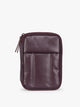 A deep burgundy Dark Cherry CALPAK Luka Zip Passport Wallet in vegan leather with a zippered top and a front pocket, shown on a plain white background; PZW2301-DARK-CHERRY-PU
