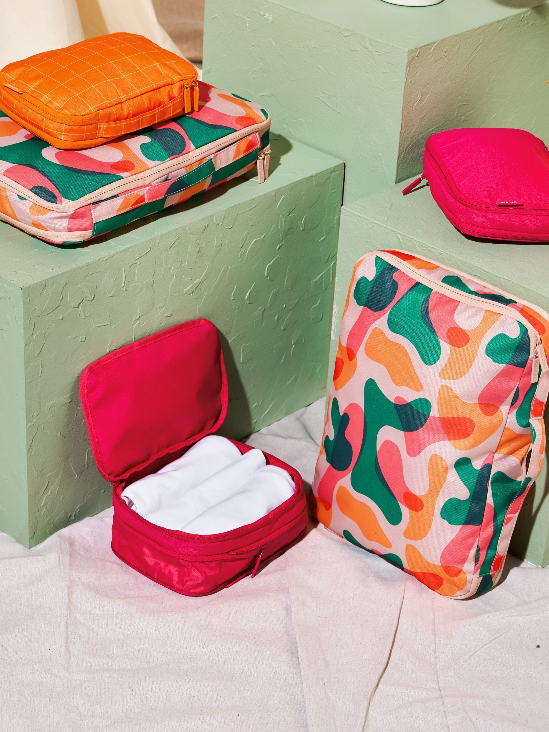 CALPAK compression packing cubes with handles in dragonfruit pink and modern abstract print; PCS2301-DRAGONFRUIT