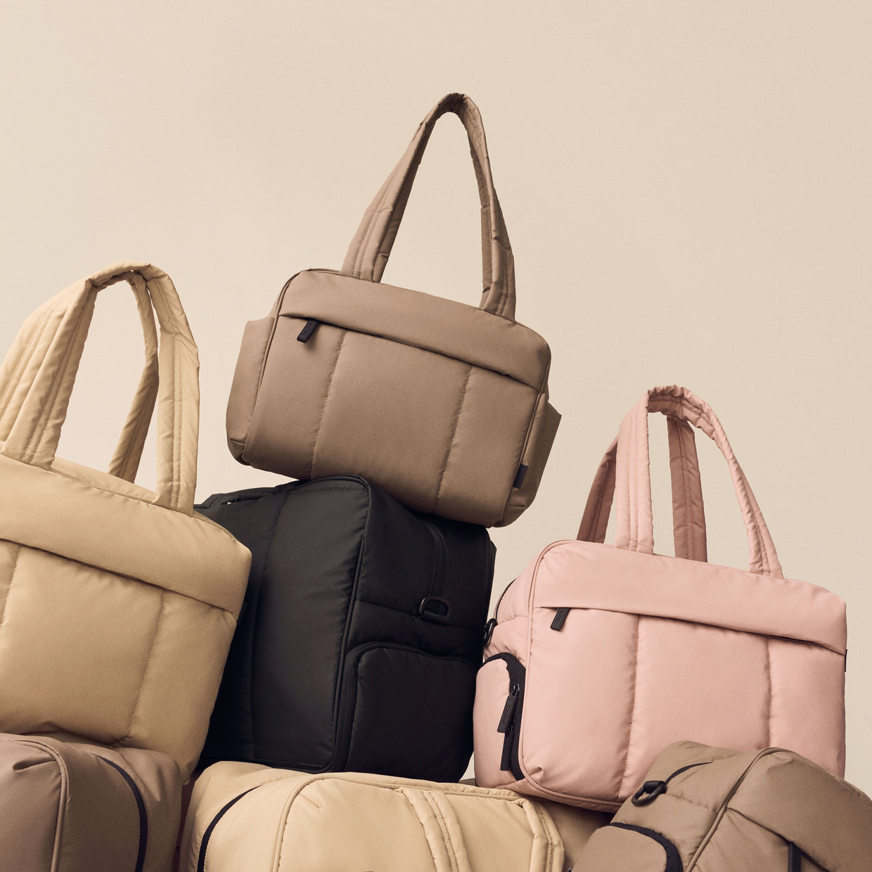 Stack of CALPAK Luka Mini Duffel in multiple colors