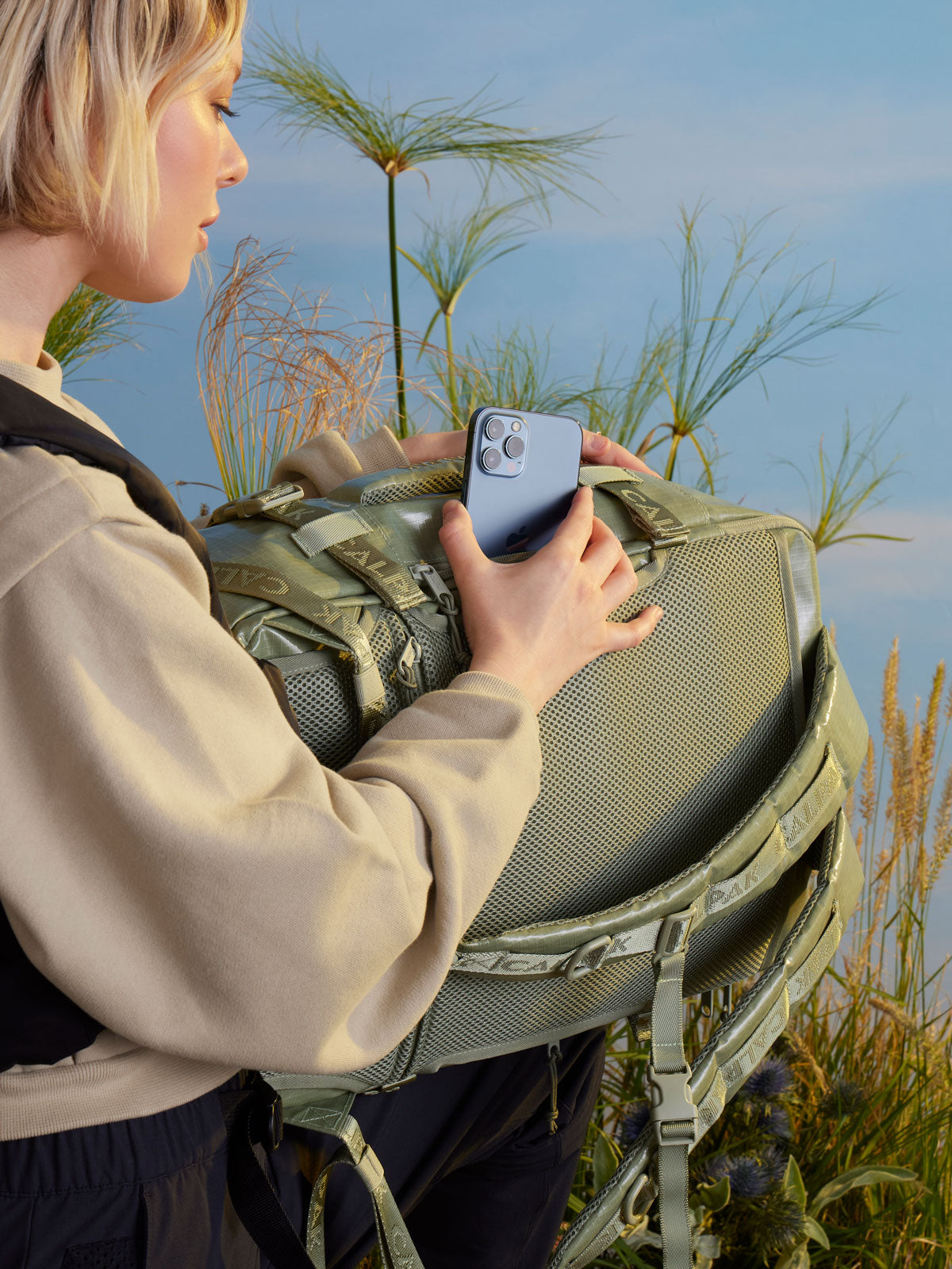 woman with CALPAK backpack duffel; BPH2201-JUNIPER