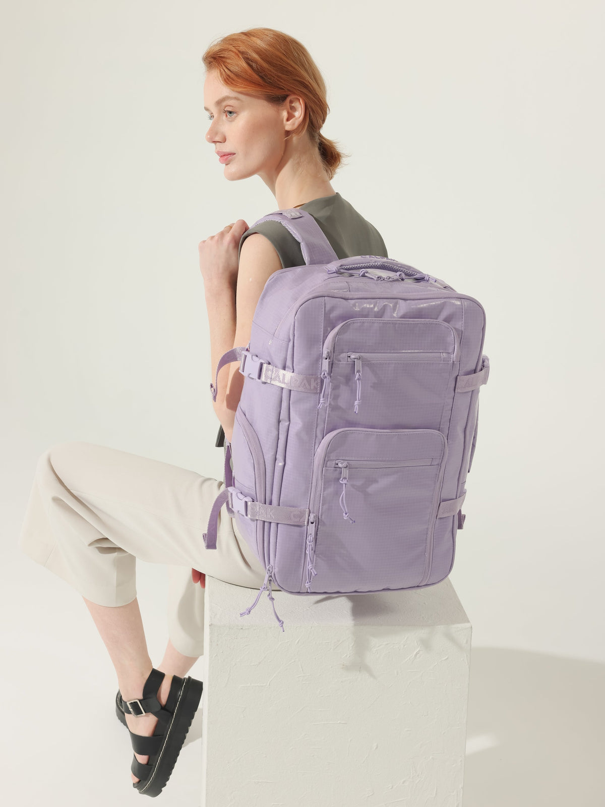 Model wearing CALPAK Terra 26L Laptop Backpack Duffel with adjustable padded shoulder straps in amethyst; BPH2201-AMETHYST