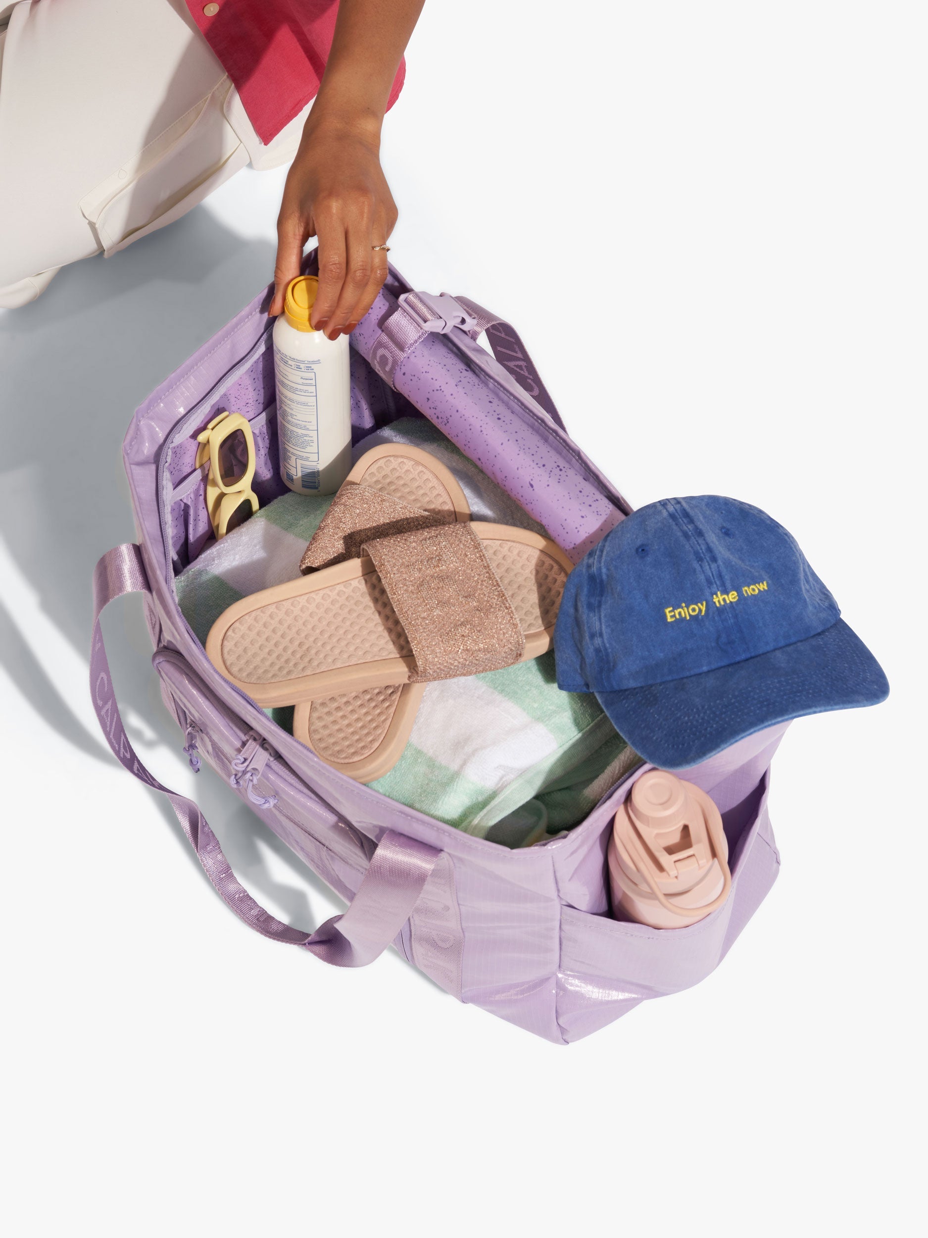 CALPAK Terra 35L Water Resistant Zippered Tote Bag interior full of items for the beach in purple; TTO2401-AMETHYST