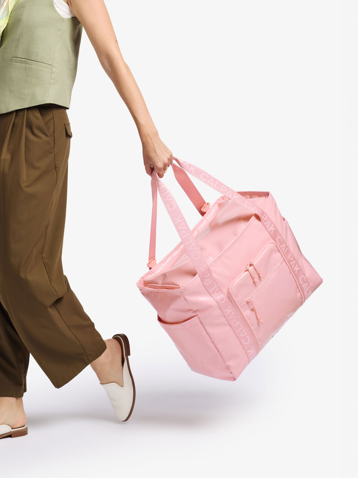 Model holding CALPAK Terra 35L Water Resistant Zippered Tote Bag by durable carrying handles in blossom pink; TTO2401-BLOSSOM