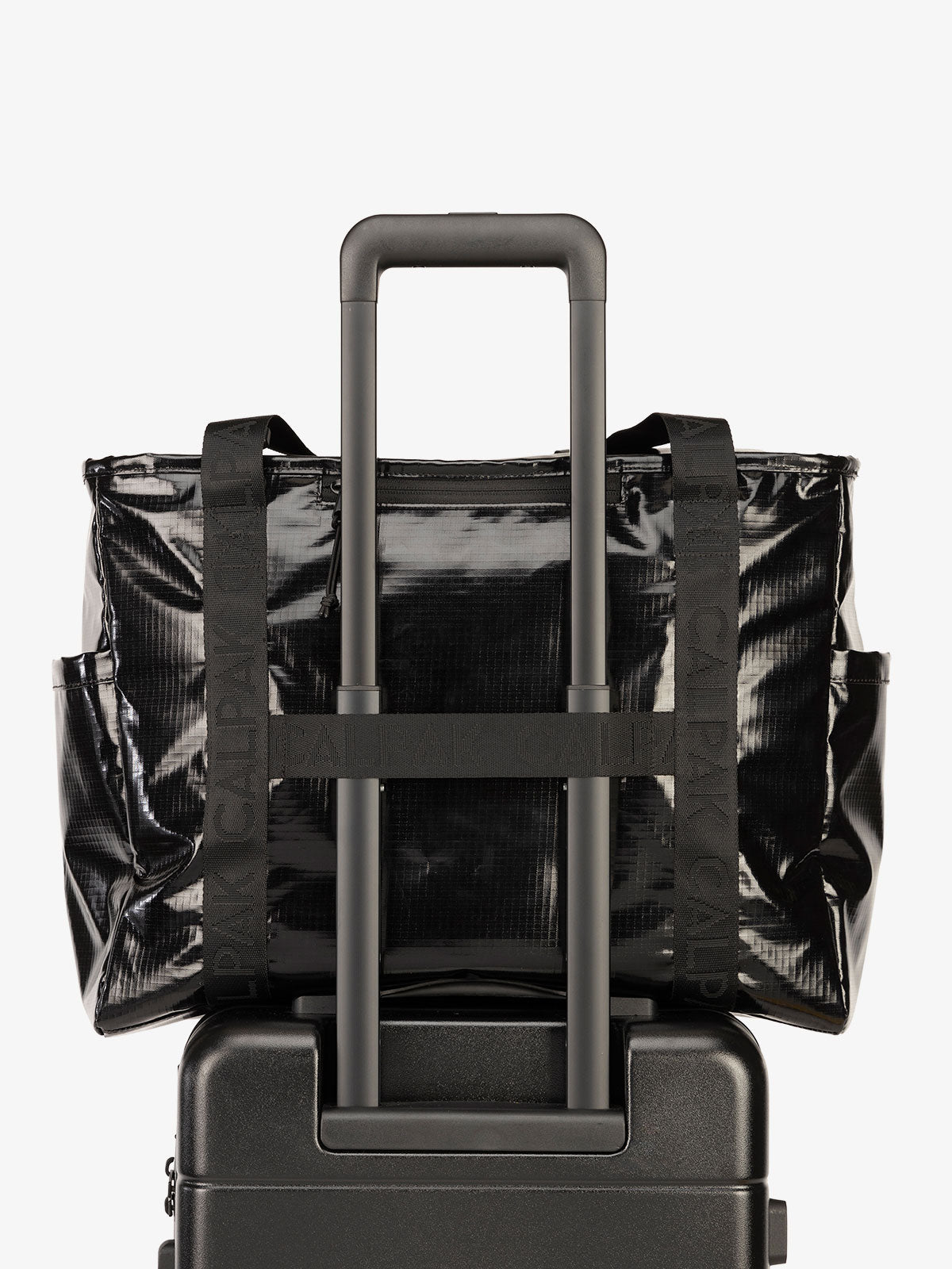 Luggage trolley sleeve of CALPAK Terra 35L Water Resistant Zippered Tote Bag in black; TTO2401-OBSIDIAN