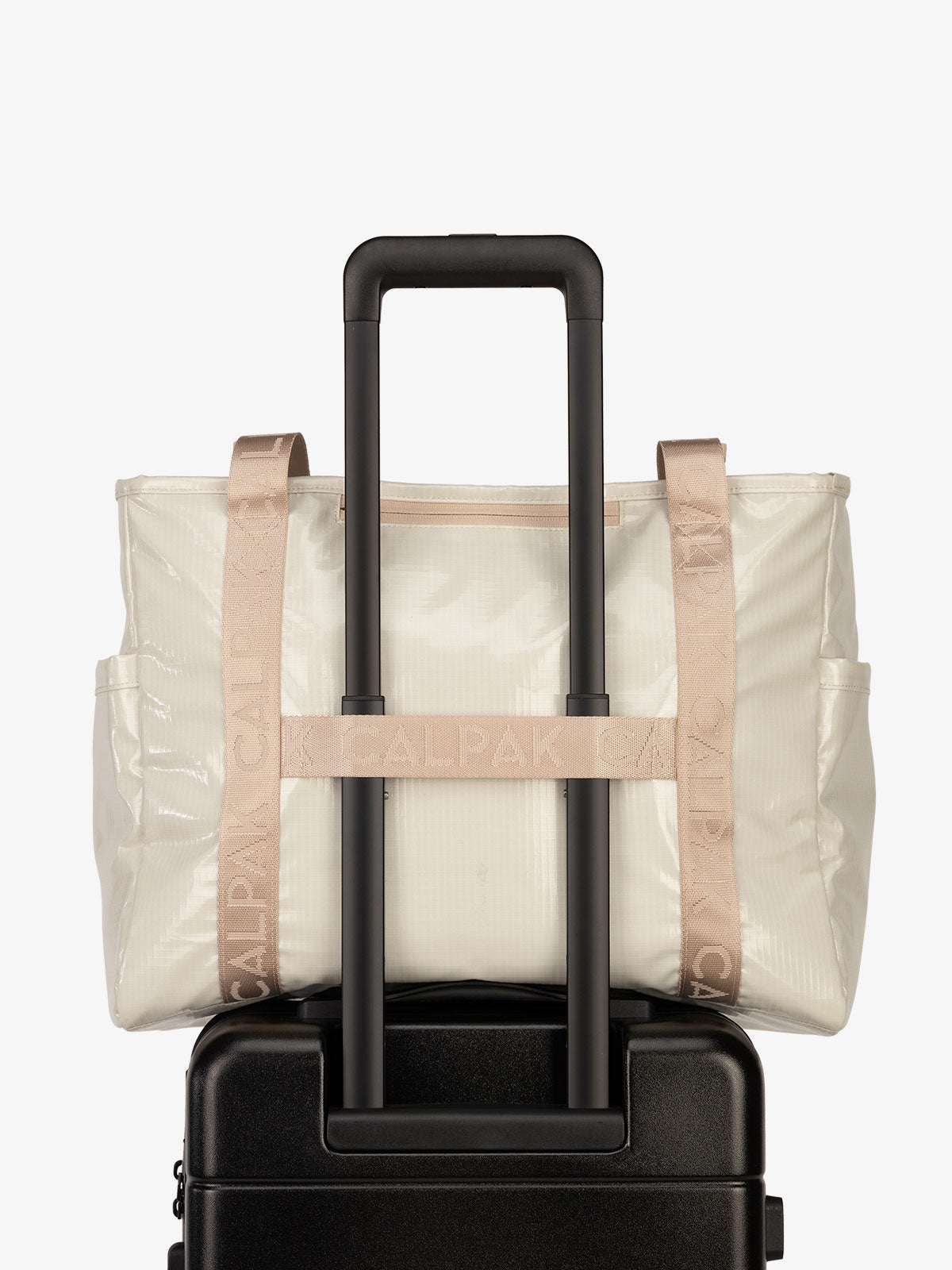Luggage trolley sleeve of CALPAK Terra 35L Water Resistant Zippered Tote Bag in white sands; TTO2401-WHITE-SANDS