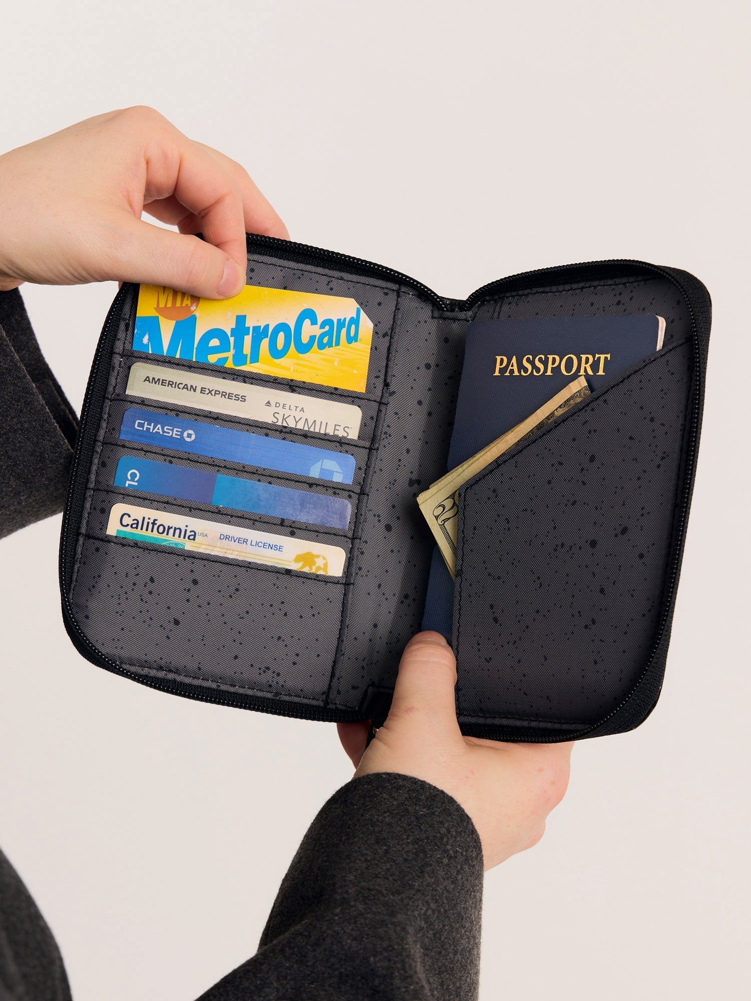 CALPAK Terra Zippered Passport Wallet in Obsidian black opened view with cards and passport; ATPW2501-OBSIDIAN
