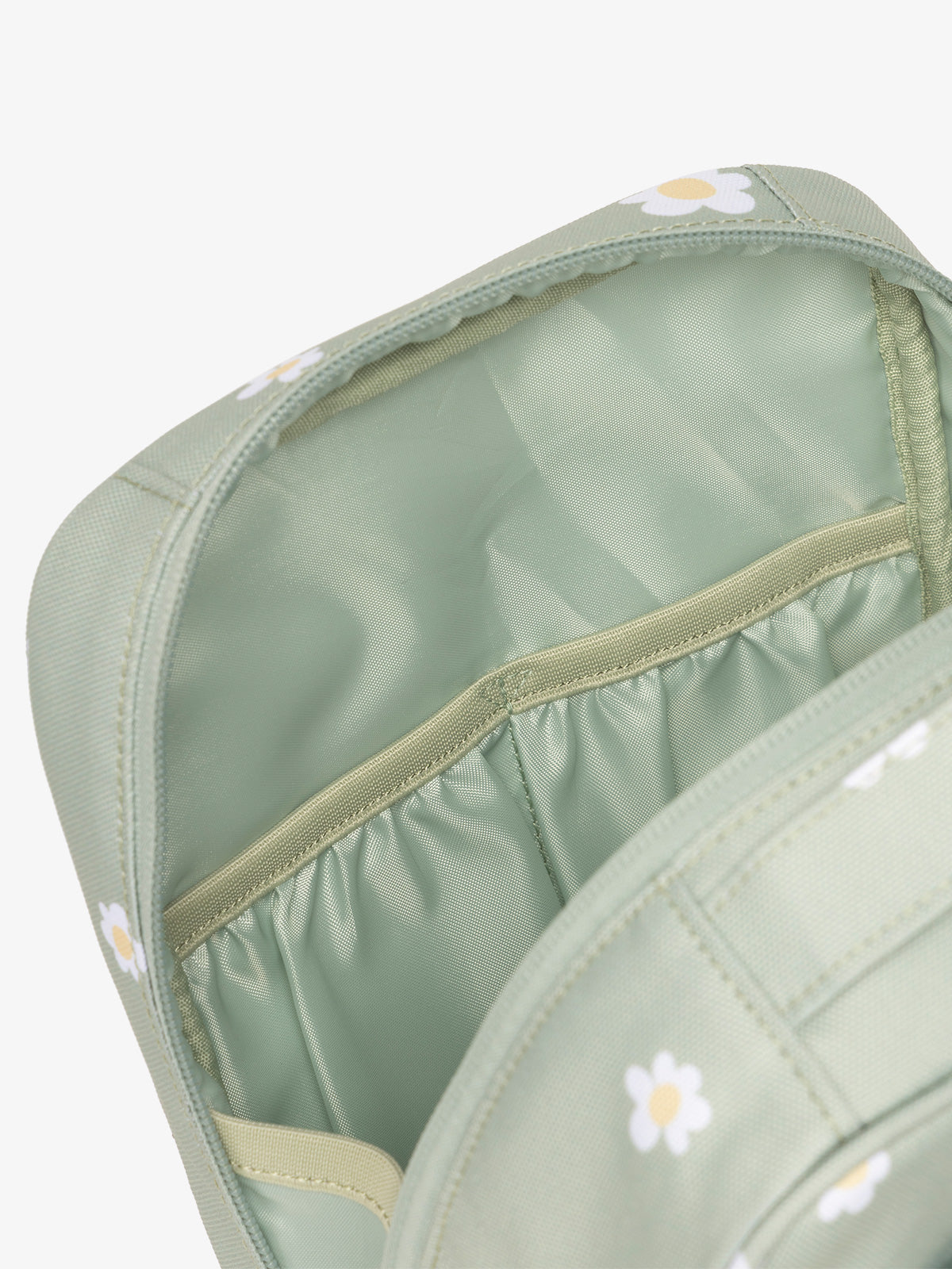 Interior view of CALPAK The Everything Cube featuring water resistant lining and interior pockets in green daisy print; ACE2401-DAISY