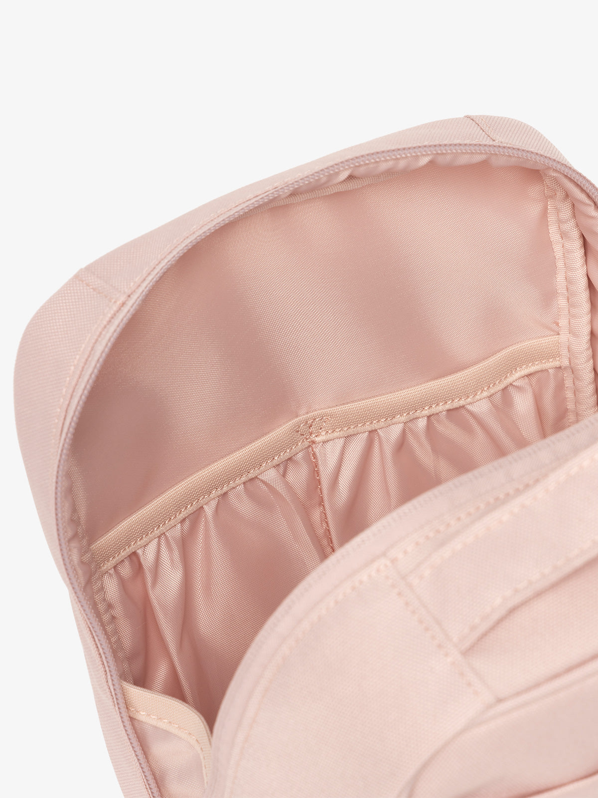 Interior view of CALPAK The Everything Cube featuring water resistant lining and interior pockets in light pink; ACE2401-PINK-SAND