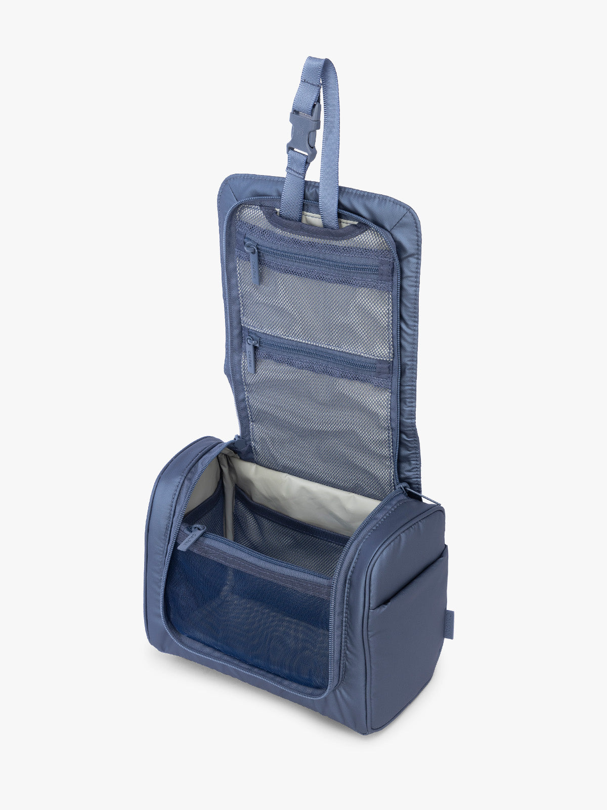 Opened view of CALPAK Luka Hanging Toiletry Bag in metallic dark blue material in Metallic Indigo; TLH2301-METALLIC-INDIGO