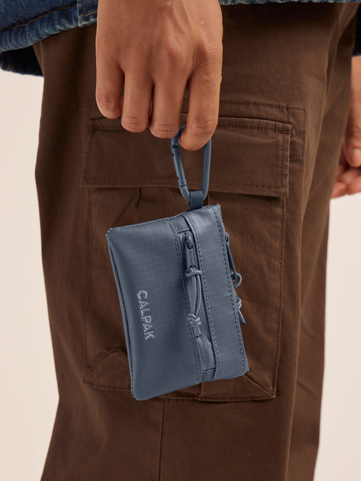 Model clipping in the CALPAK Terra Clippable Card Pouch in blue Matte Indigo; TPC2401-INDIGO