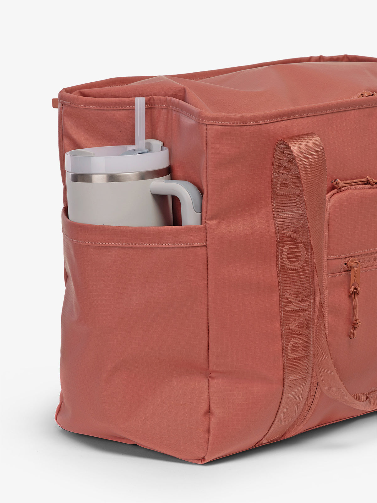 CALPAK Terra 35L Water Resistant Zippered Tote Bag in red and orange Matte Clay side pocket used as as water bottle holder; TTO2401-CLAY