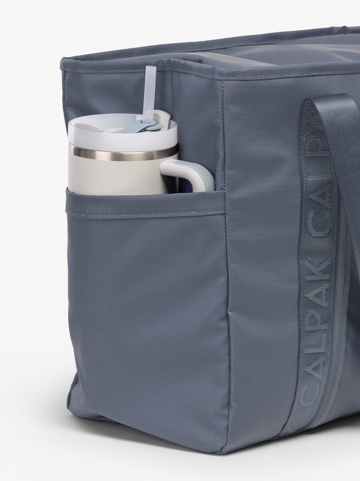 CALPAK Terra 35L Water Resistant Zippered Tote Bag in blue Matte Indigo side pocket used as as water bottle holder; TTO2401-INDIGO