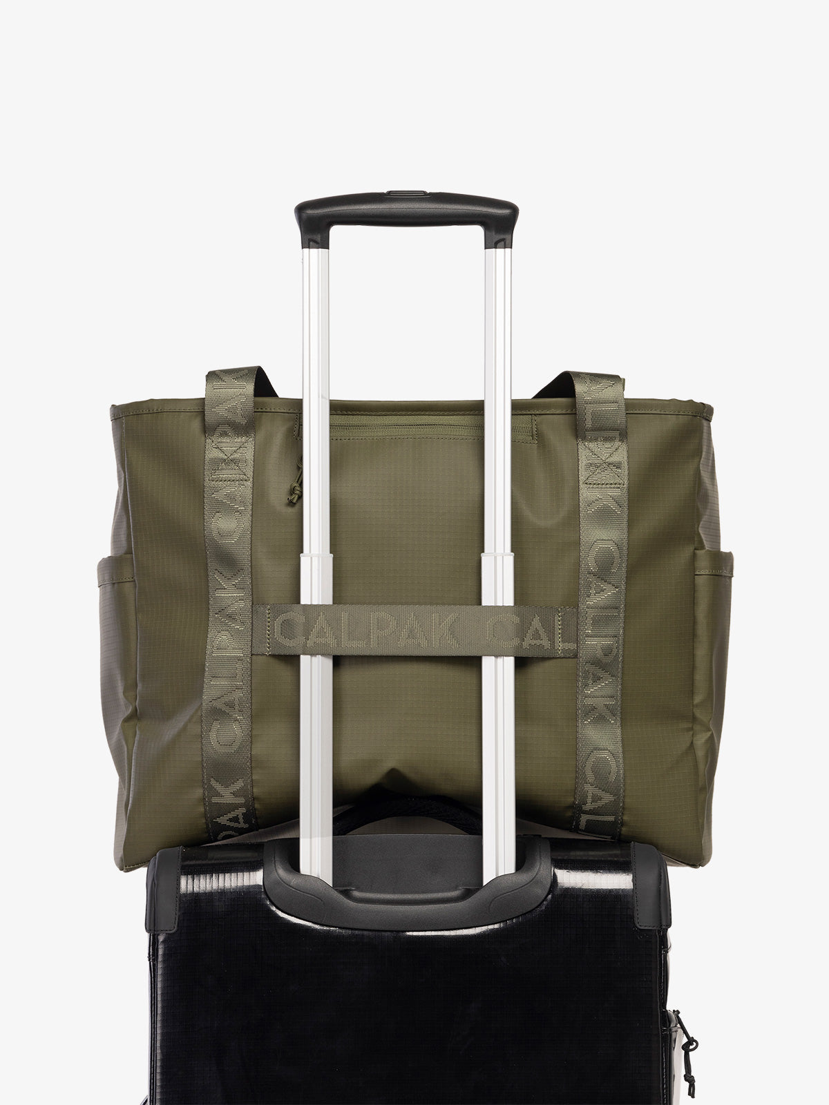 CALPAK Terra 35L Water Resistant Zippered Tote Bag in dark green Matte Pine on suitcase with trolley sleeve; TTO2401-PINE