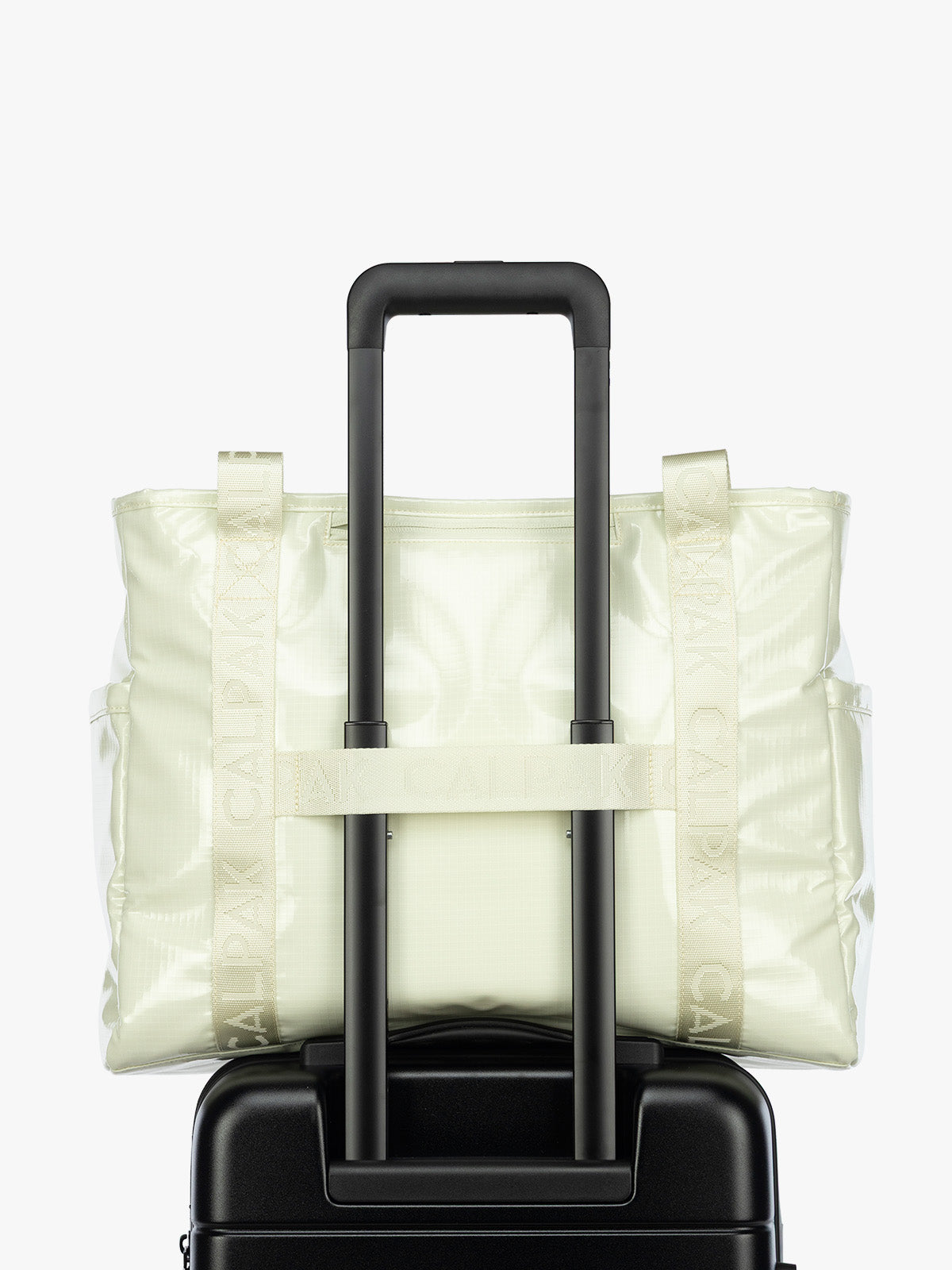 Luggage trolley strap of the CALPAK Terra 35L Tote Bag with multiple pockets and shoulder straps in shiny light green Celadon on a white background; TTO2401-CELADON