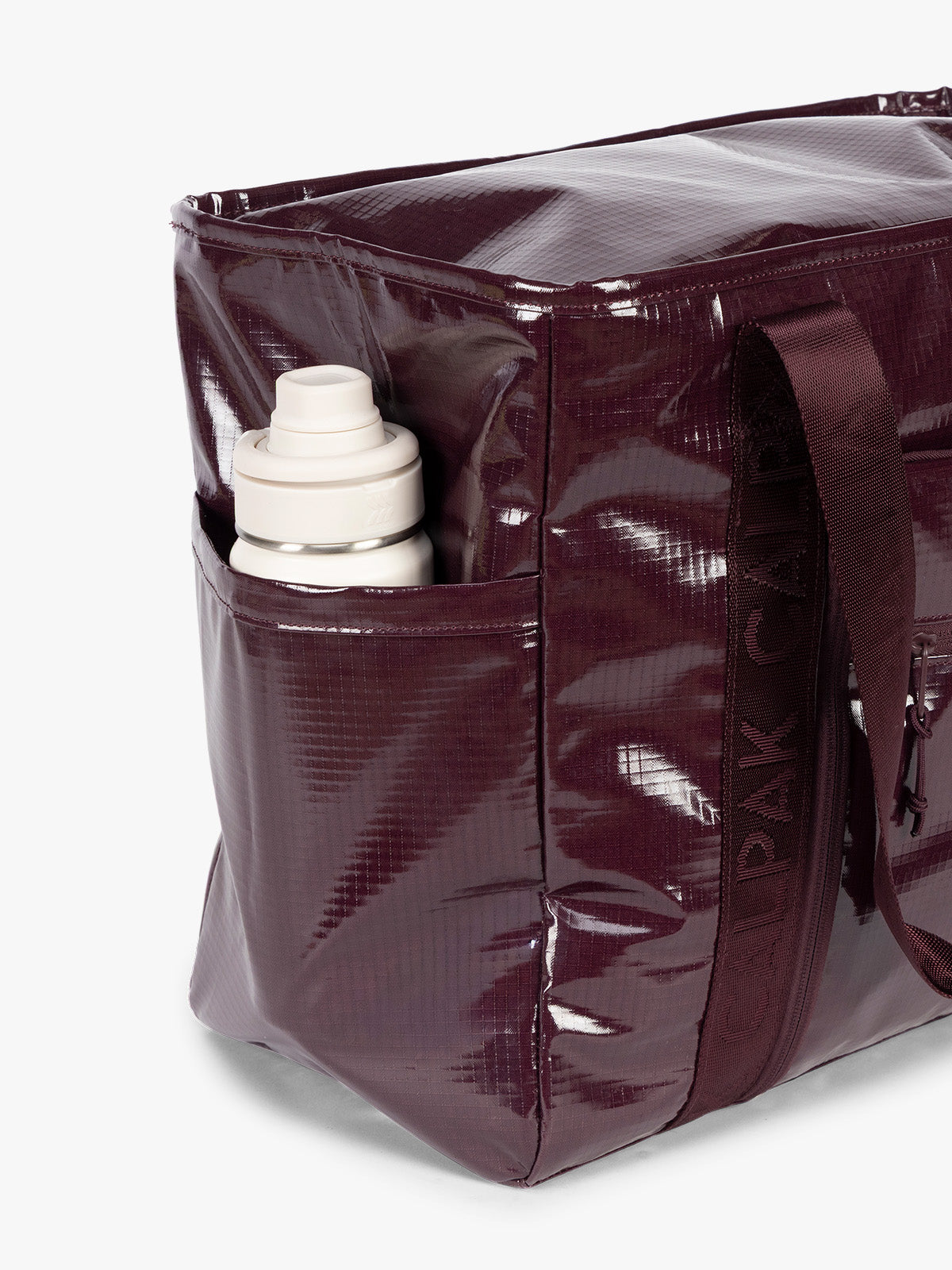 Side water bottle holder of CALPAK Terra 35L Tote Bag with zippers in dark red Dark Cherry on a white background; TTO2401-DARK-CHERRY