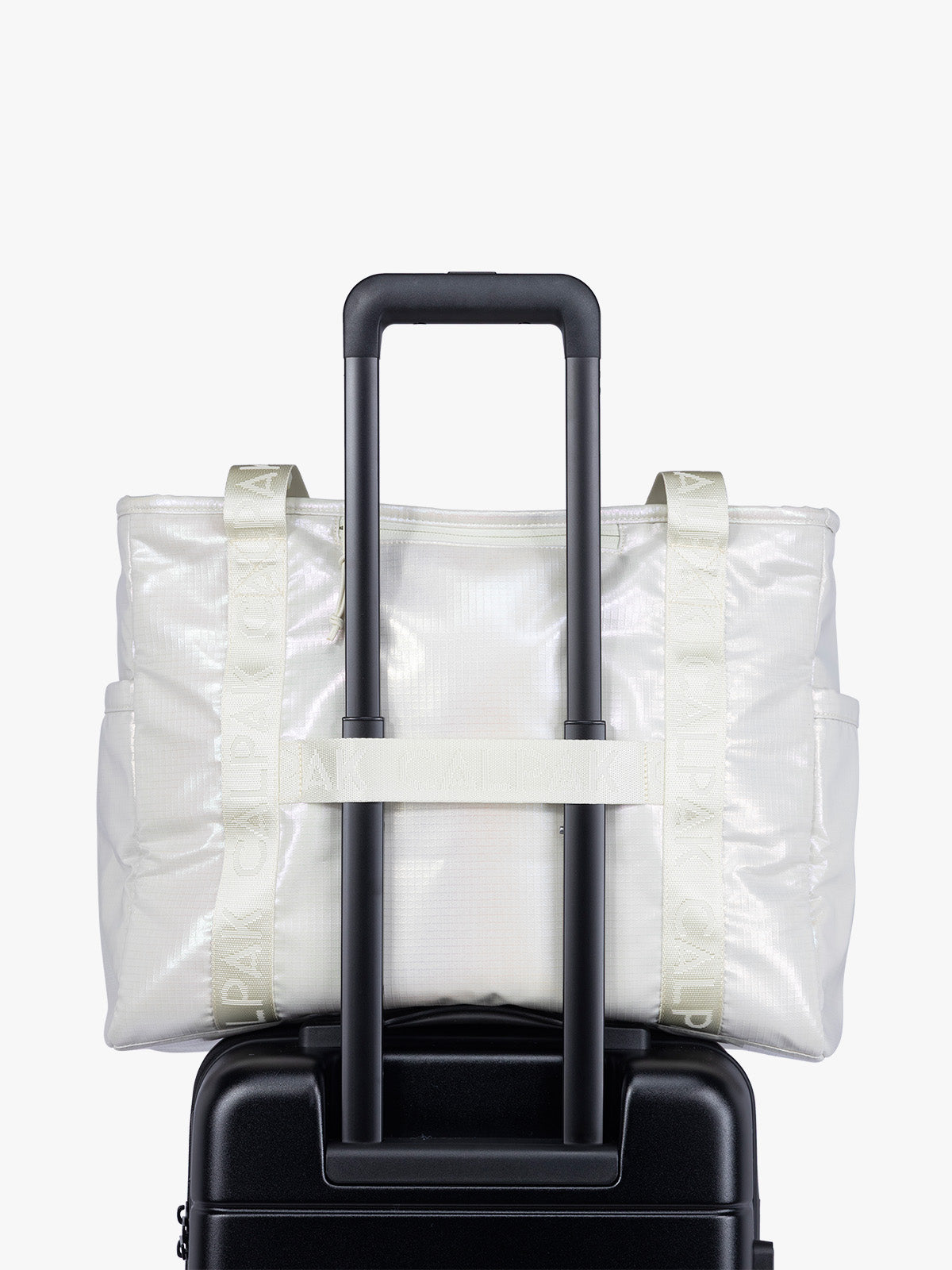 Trolley sleeve component of CALPAK Terra 35L Tote Bag with multiple pockets and shoulder straps in shiny white Moonbeam on a white background; TTO2401-MOONBEAM
