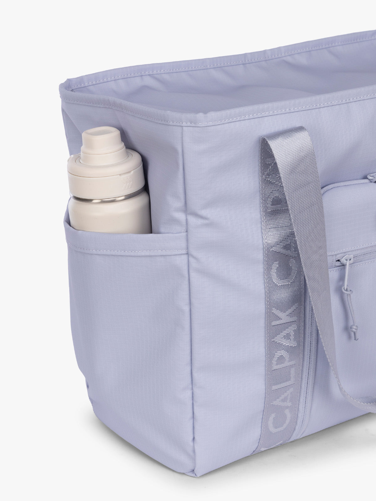 Side water bottle pocket of the CALPAK Terra 35L Tote Bag with multiple pockets and shoulder straps in shiny light lavender Sea Glass on a white background; TTO2401-SEA-GLASS