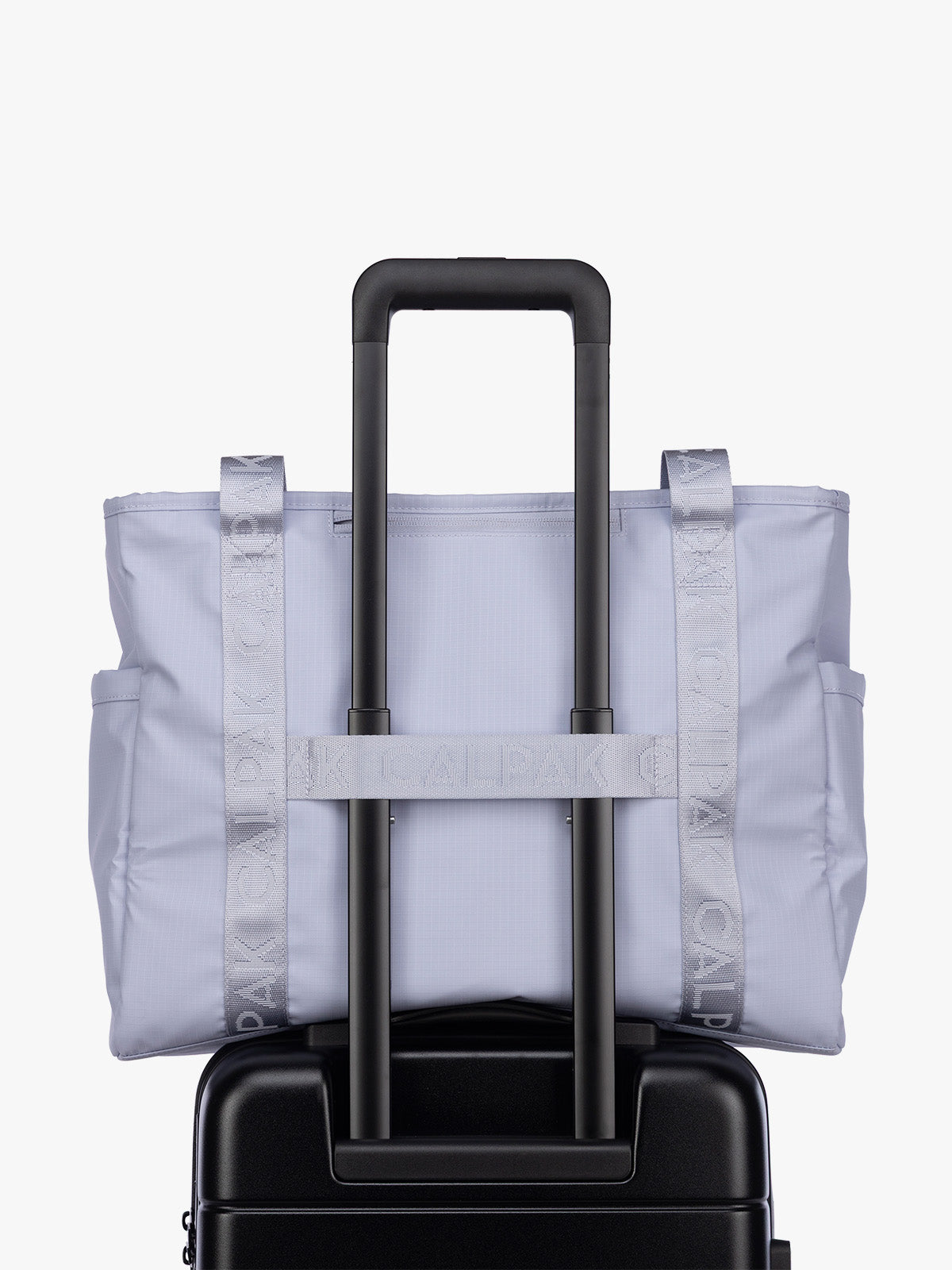 Luggage trolley strap of the CALPAK Terra 35L Tote Bag with multiple pockets and shoulder straps in shiny light lavender Sea Glass on a white background; TTO2401-SEA-GLASS
