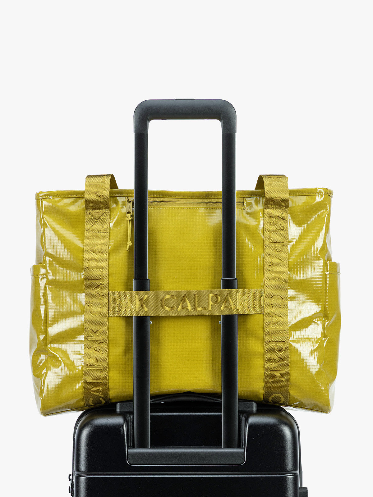 Back trolley sleeve of CALPAK Terra 35L Tote Bag with zippers in yellow green Wasabi on a white background; TTO2401-WASABI