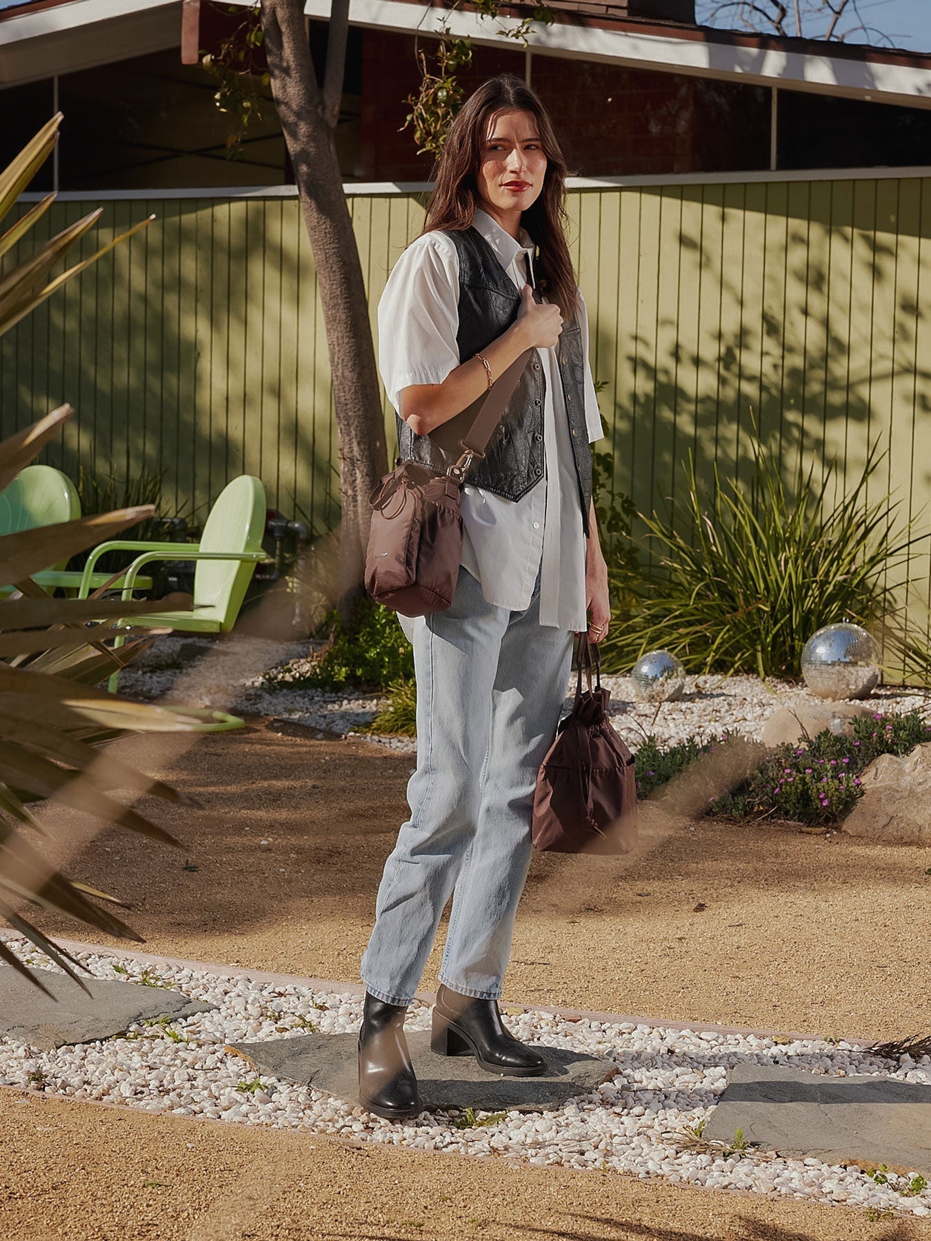 Model carrying CALPAK Water Bottle Holder with detachable sling and zipped front pocket in walnut brown; AWH2101-WALNUT