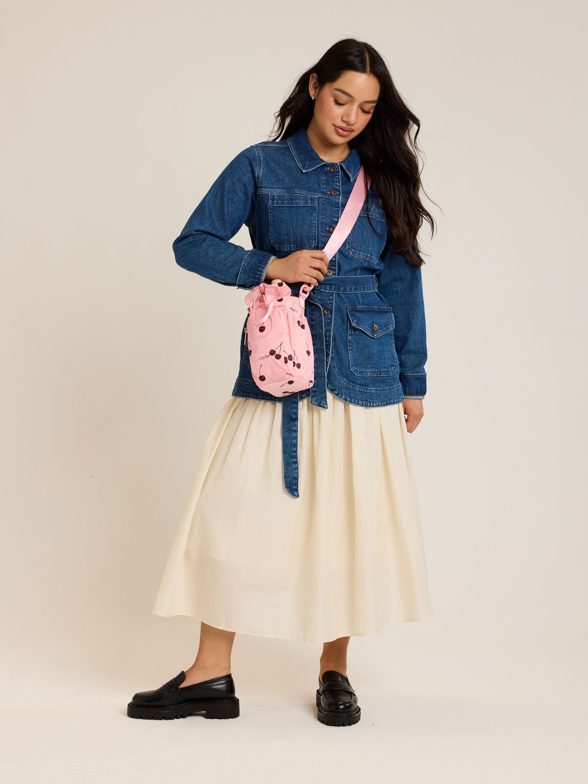 Model holding CALPAK Water Bottle Holder in Oatmeal Chery in pink with cherry pattern; AWH2101-BLOSSOM-CHERRY
