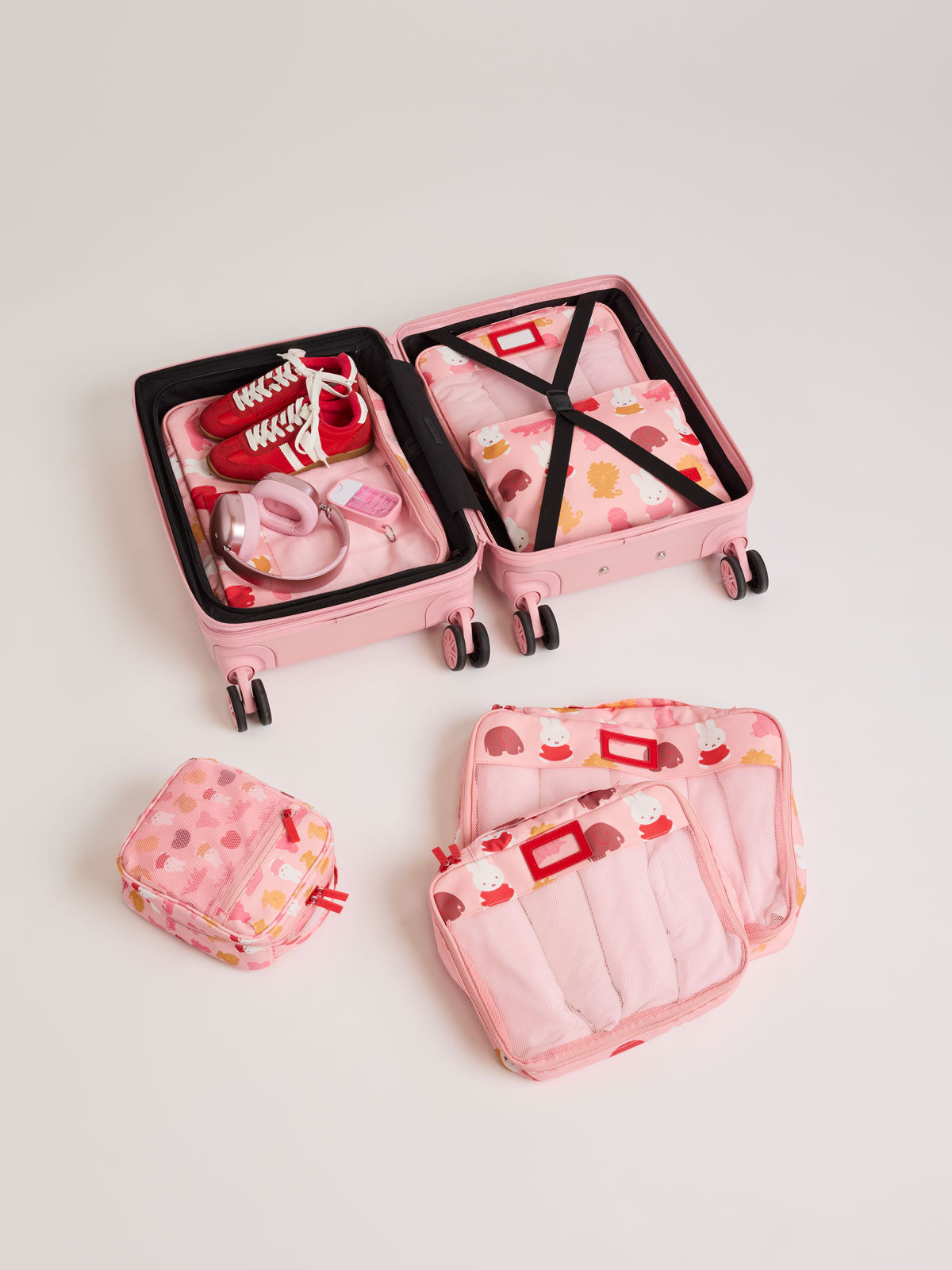 Set of CALPAK Packing Cubes in colorful pink pouches with Miffy and animal pattern  packed in a suitcase on a white background; PC1601-MIFFY-PINK-ZOO-TRIP