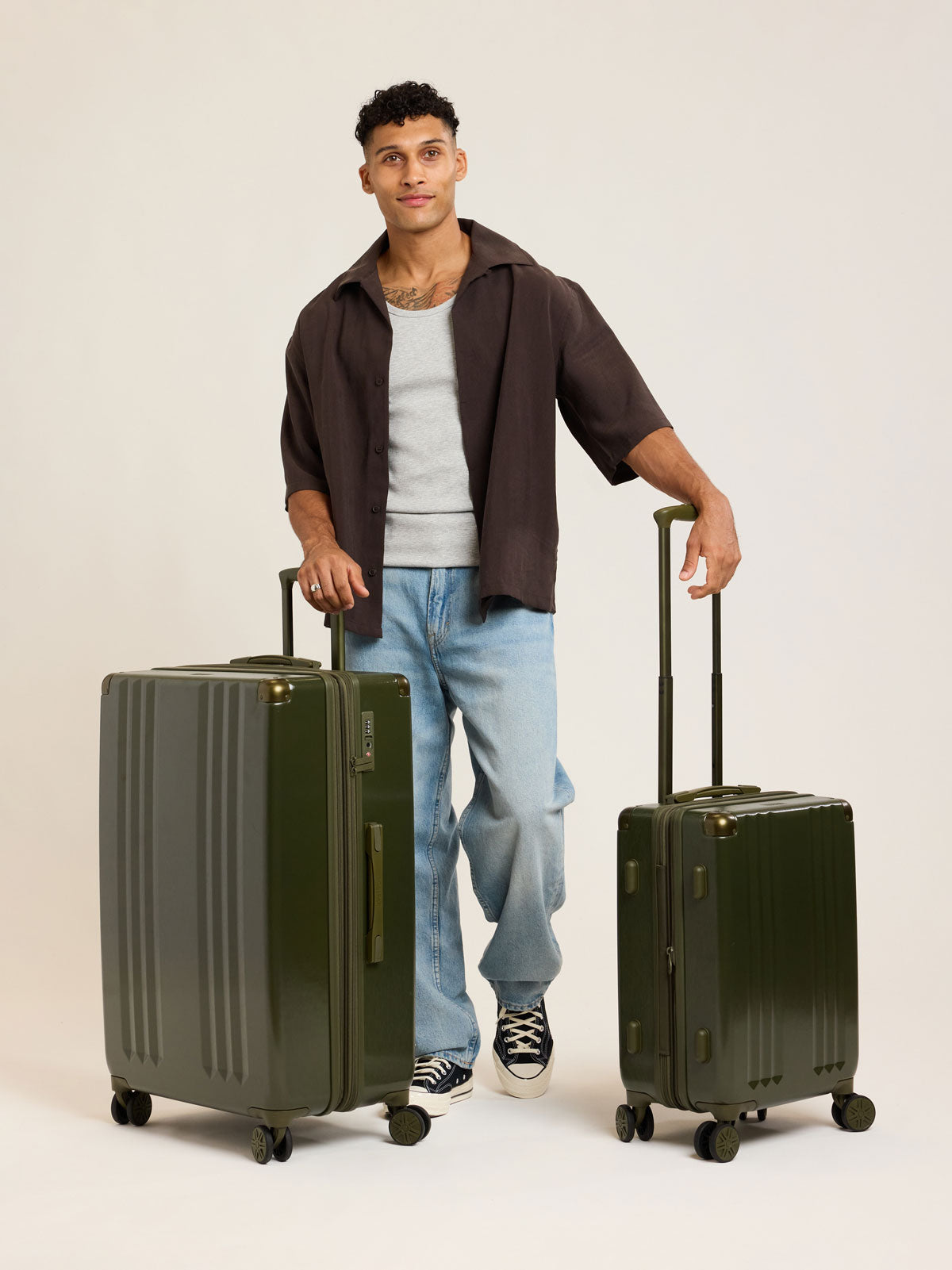 Model with CALPAK dark green Pine 2pc Luggage Set; LAM2000-PINE
