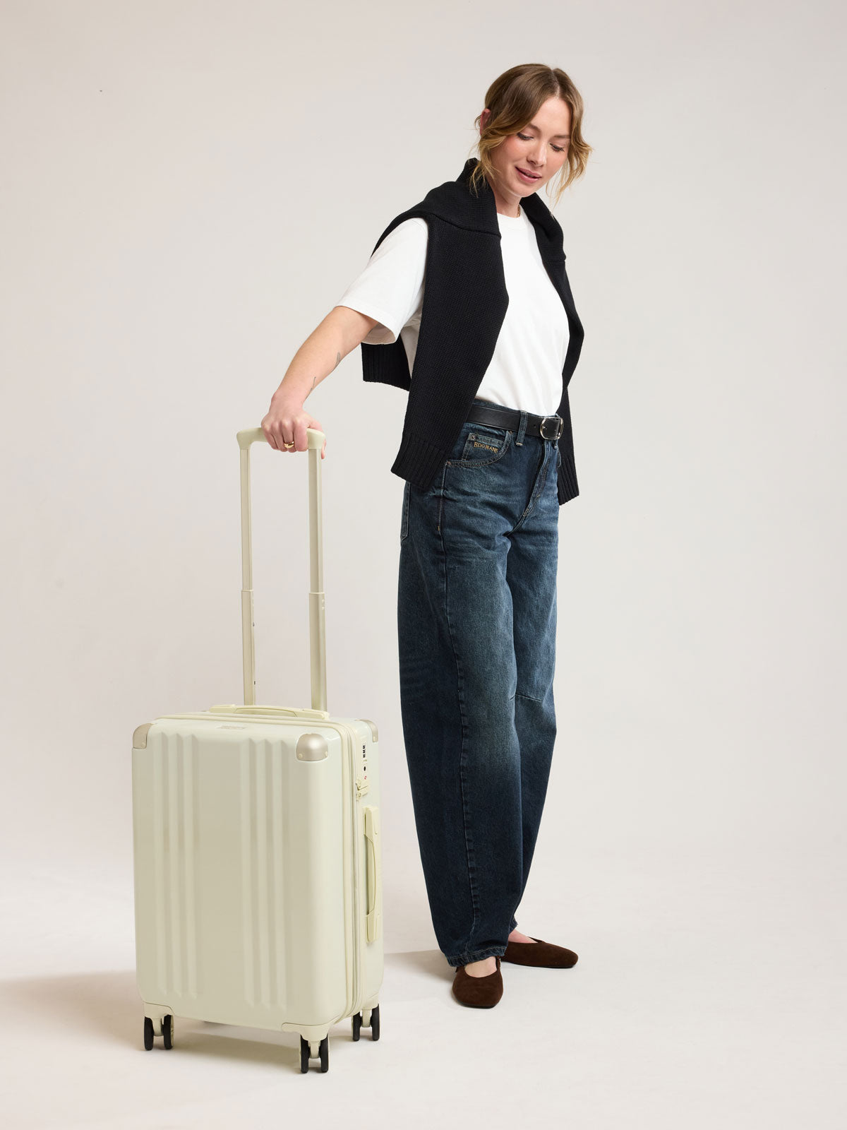 Woman with CALPAK Ambeur Carry on Luggage in light green Celadon; LAM1020-CELADON