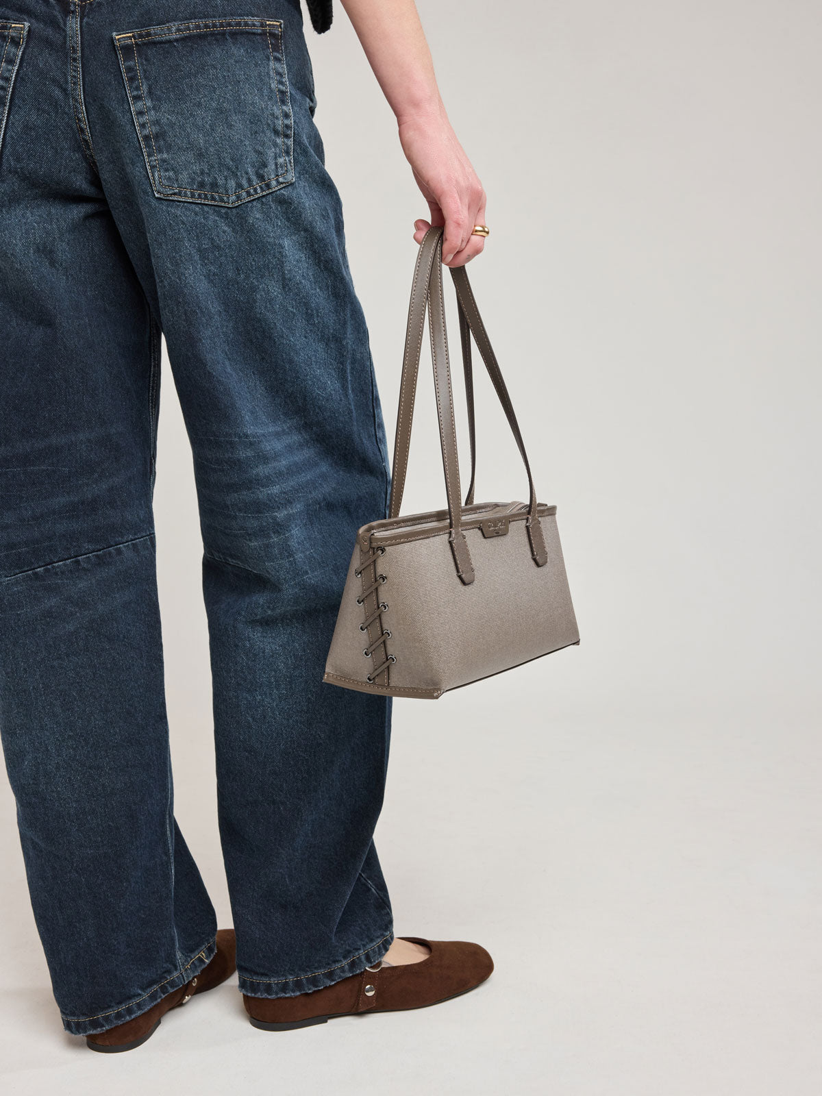 Woman holding CALPAK Colette Canvas Shoulder Tote in brown Mushroom canvas material ; CLST2601-MUSHROOM