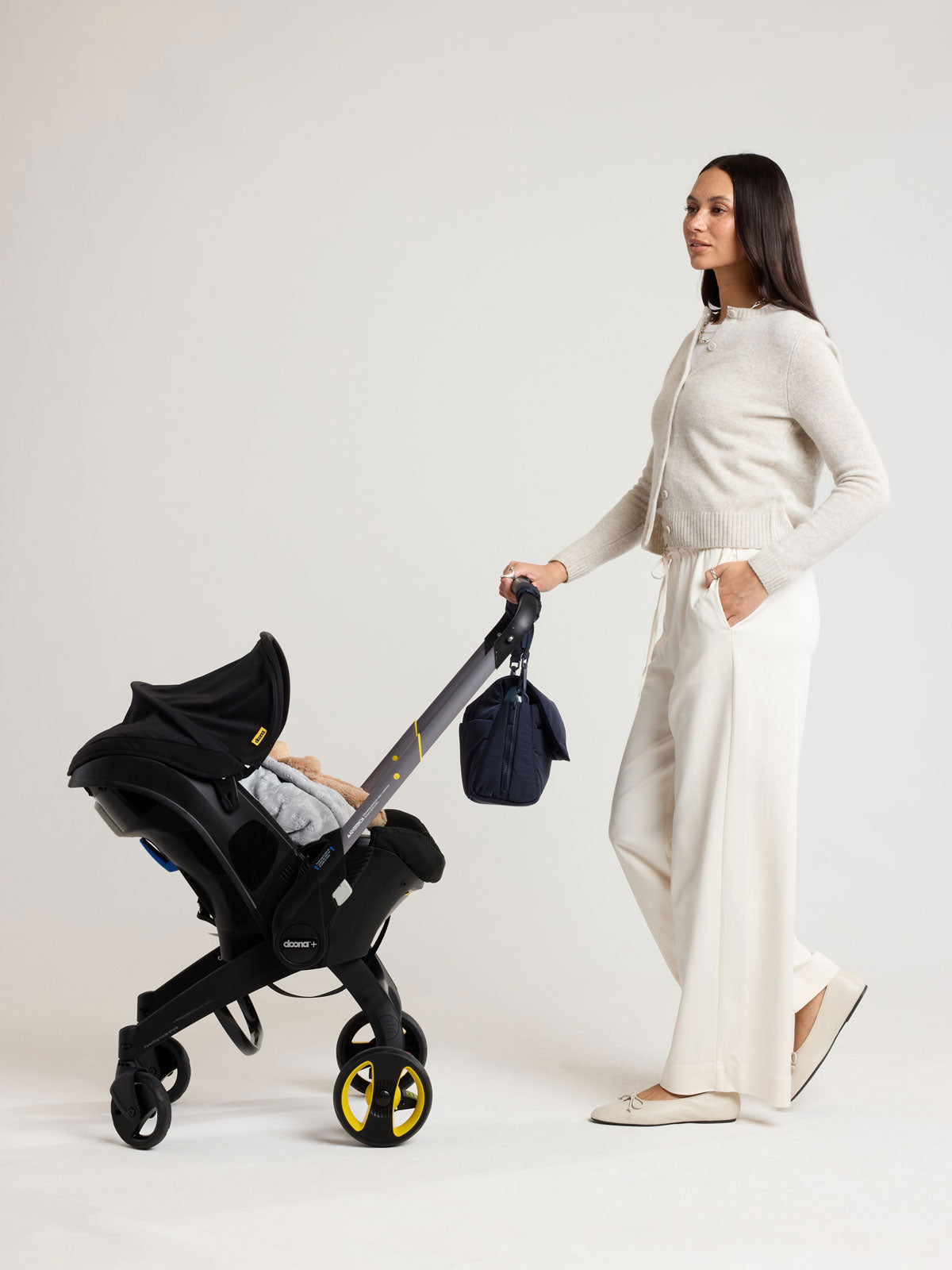 Woman with CALPAK Convertible Stroller Cady in blue Navy on a stroller; SCB2401-NAVY